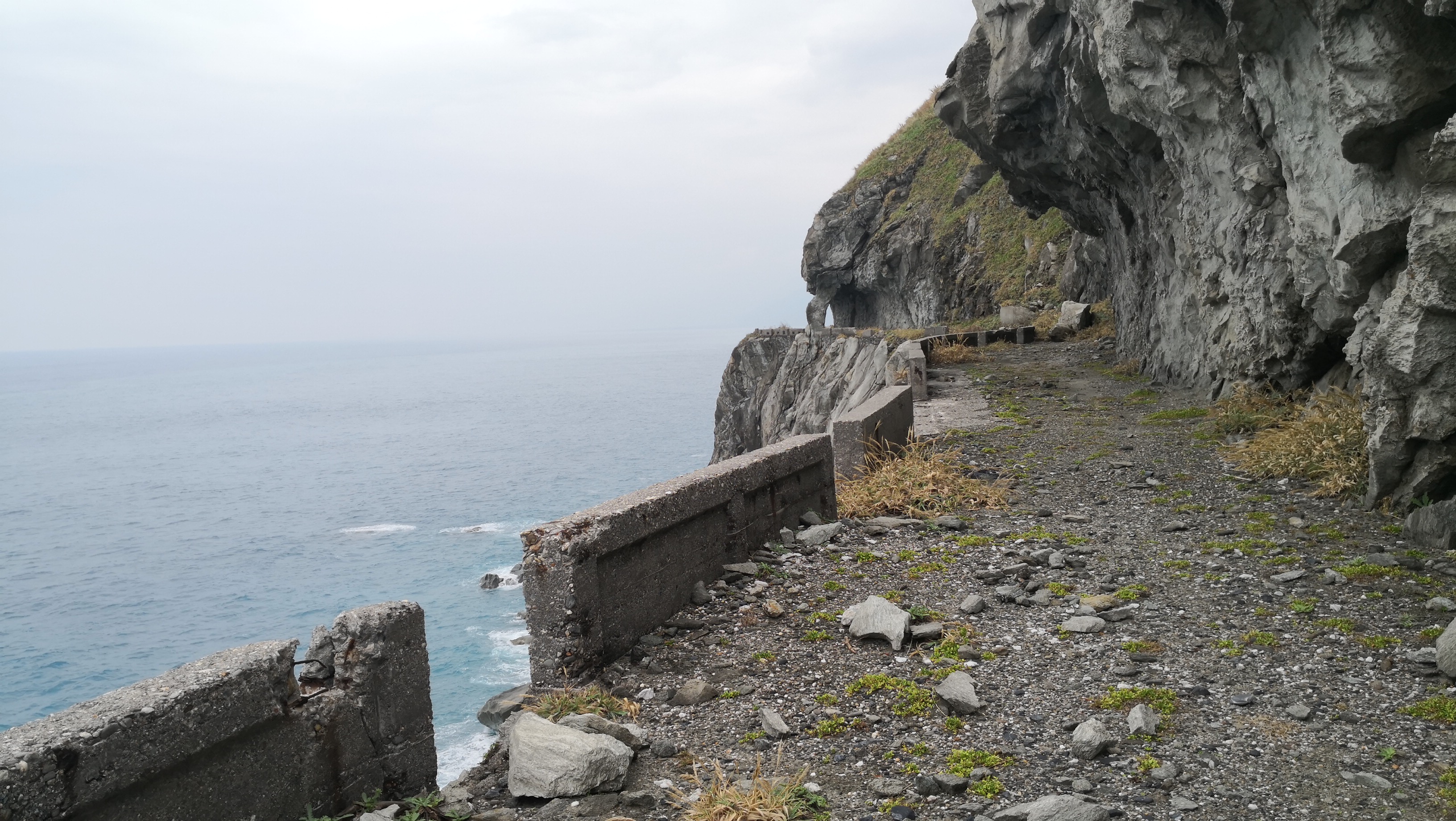 曾經的臨海道路旁仍留有圍籬，看得出路面並不寬廣。