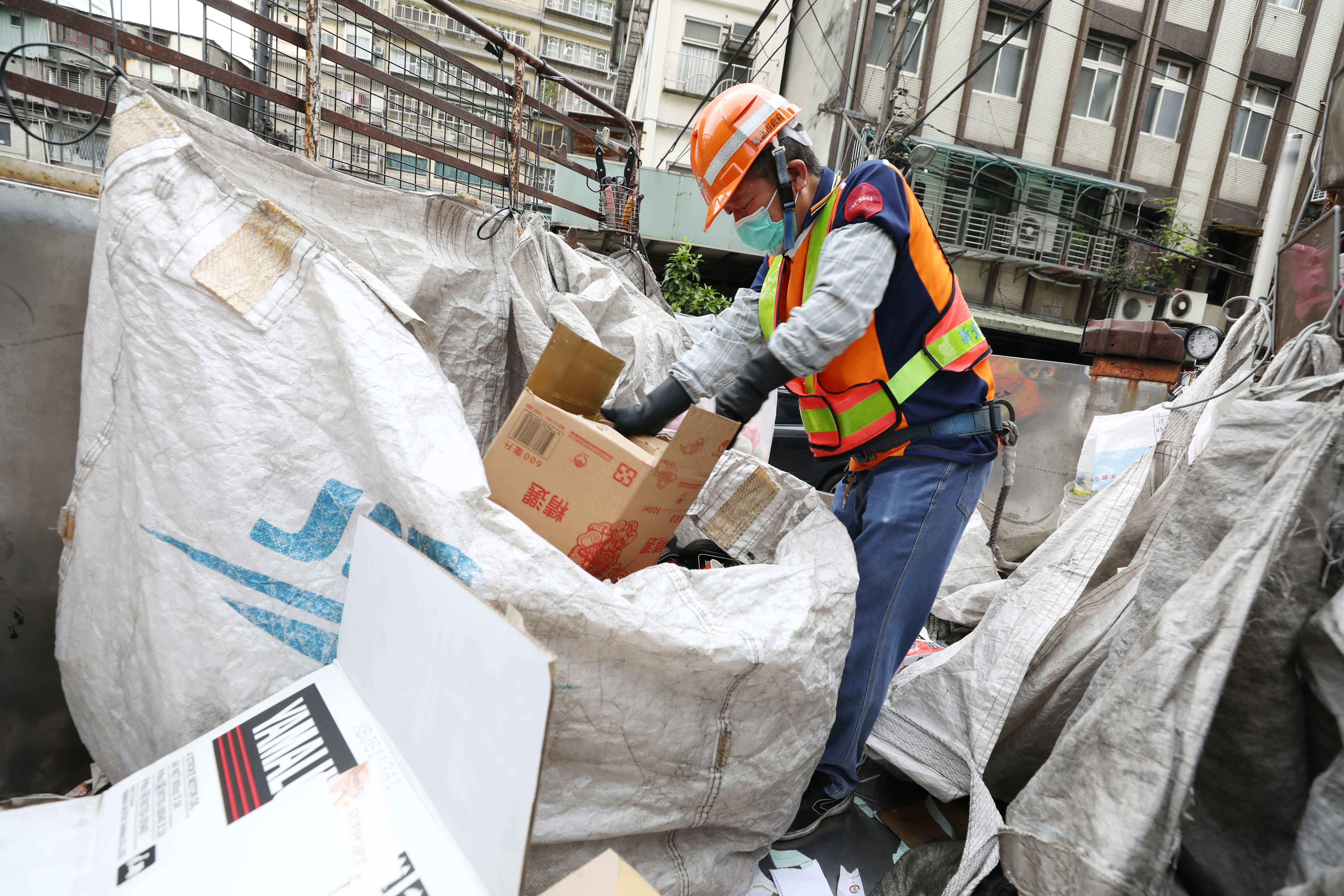 資源回收車上的工作十分繁重，除了接民眾的回收物品，車子行駛途中也得趁空快速分類。