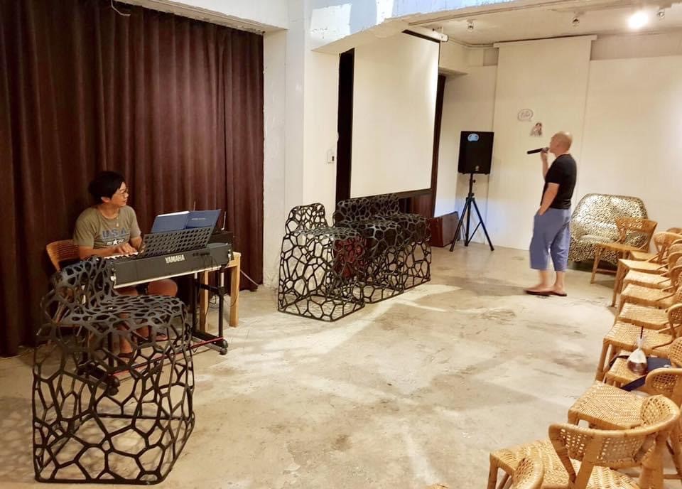 曹源峰彈琴（左）陪導演蔡明亮（右）練習演唱單曲〈光〉。（曹源峰提供）