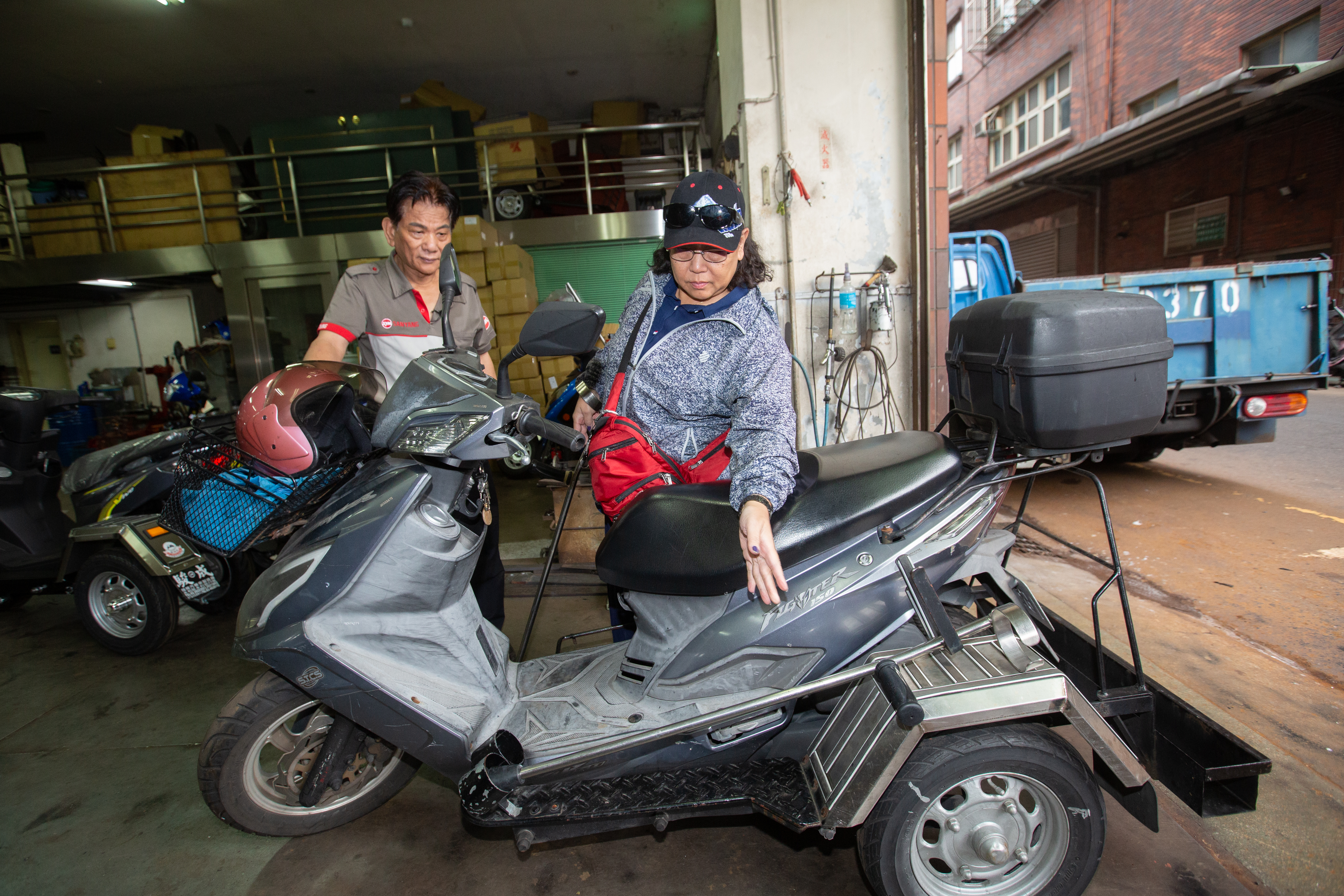 謝建台(左)把身障族當作改車老師,使命必達打造客製化零件。