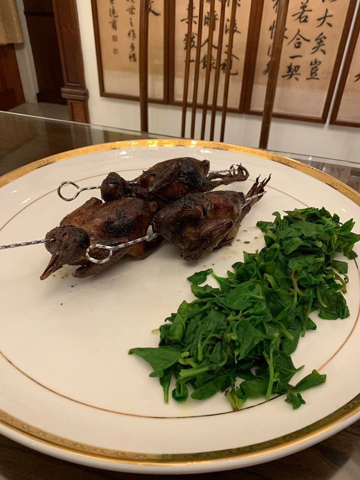 烤乳鴿完成上桌，汆燙好小菠菜葉，放在盤上當作配菜。