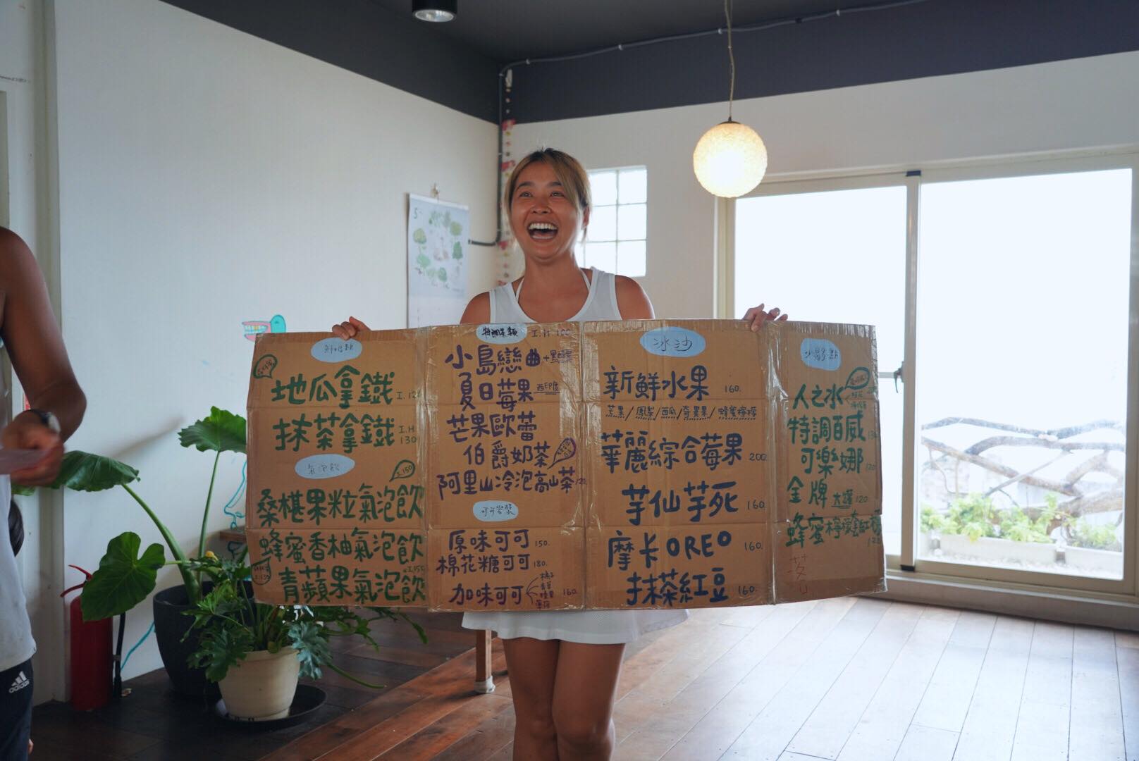 小嫻人在蘭嶼舉著飲料菜單紙牌，笑得非常燦爛。（翻攝自隋棠 Sonia Sui臉書）