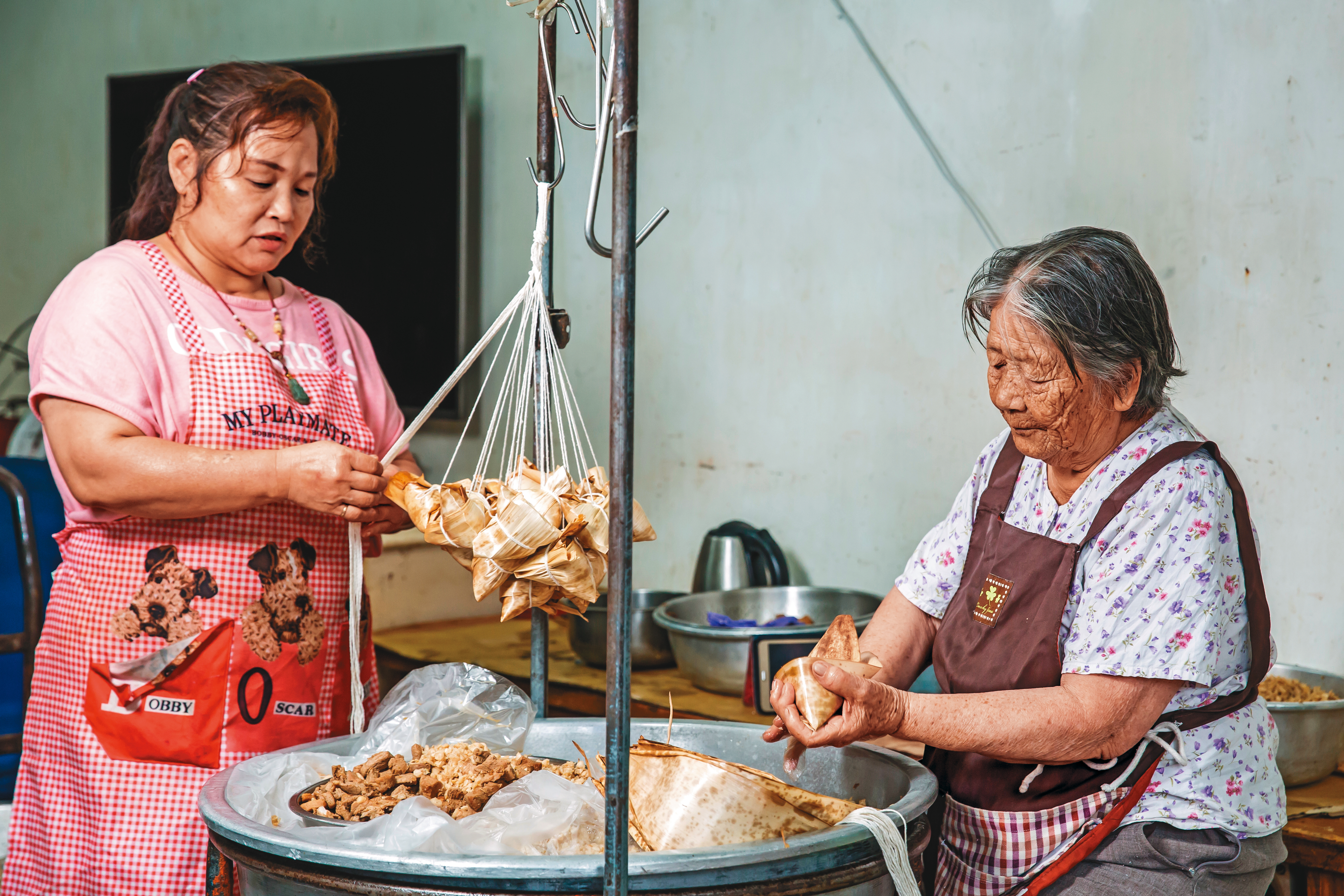 林蜂（右）的女兒江春蘭（左）幾年前婚變回家，現在在家幫忙母親，平日晚上也會出門擺攤。