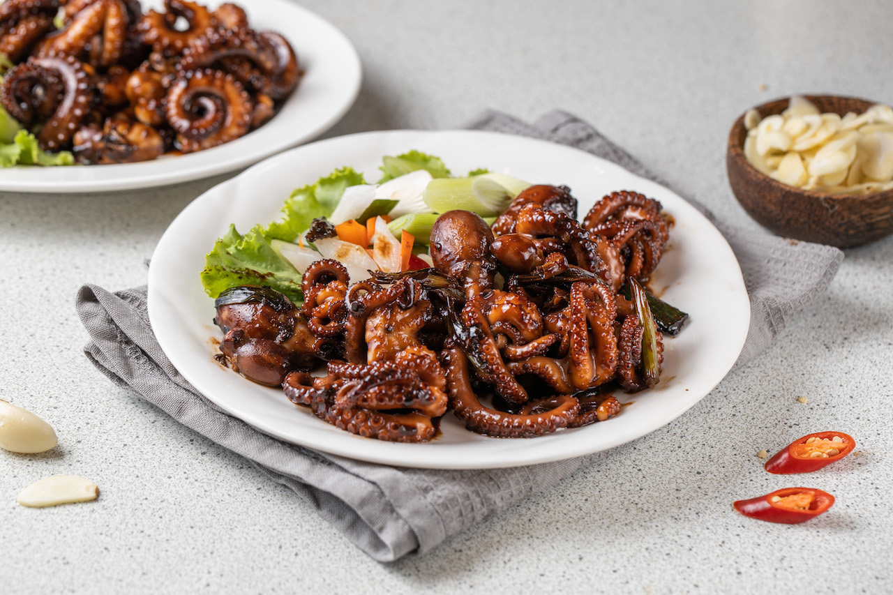 「澎湖蟹黃章魚」鮮甜會爆漿（前，2,000元／斤；圖中為1,000元／份，需預訂）；鹹甘挺脆的「澎湖黑糖章魚」（後，380元／份）。