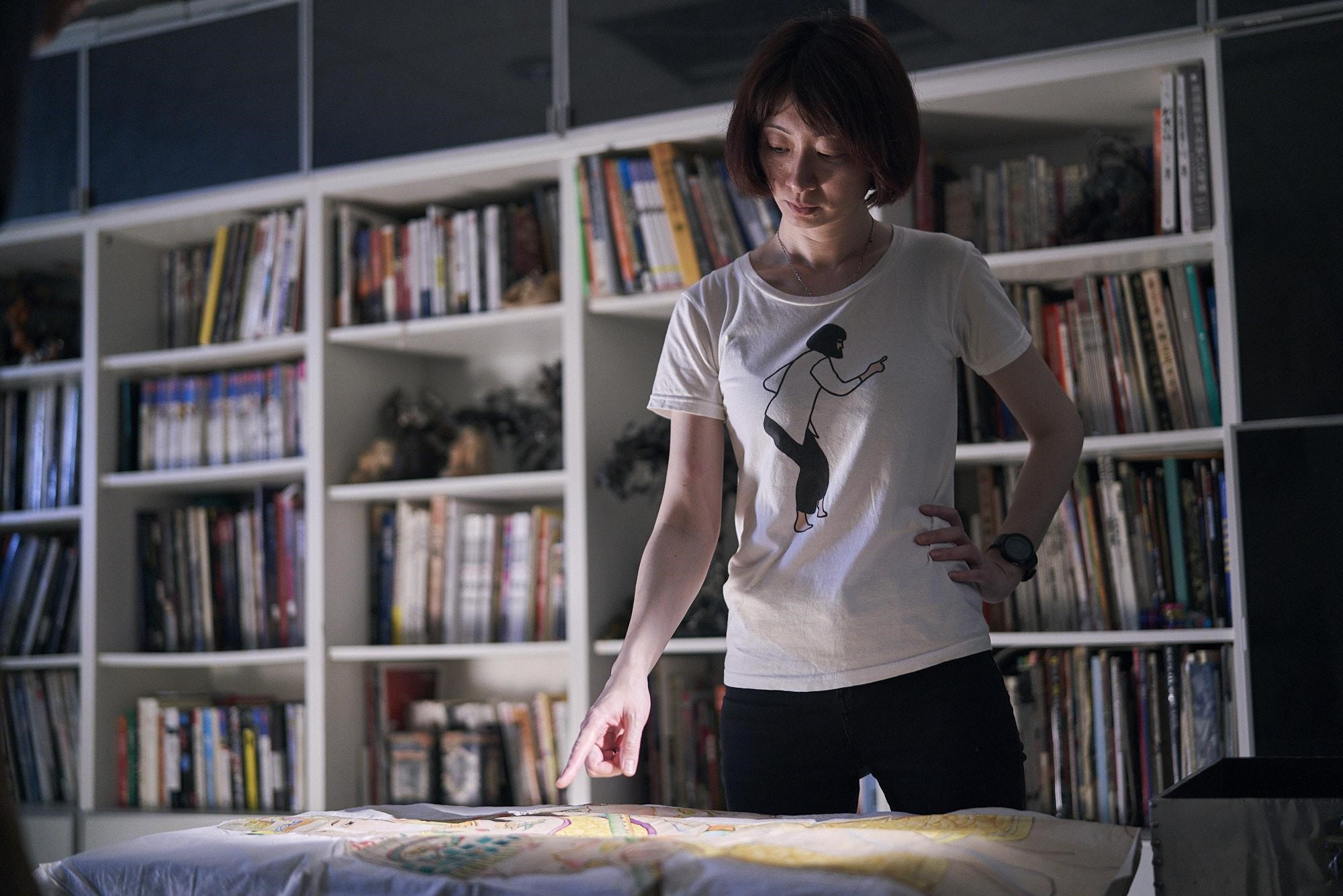 王婉柔在開拍前，仔細觀察鄭問的原畫真跡，構思拍攝方法。（貝殼放大提供）