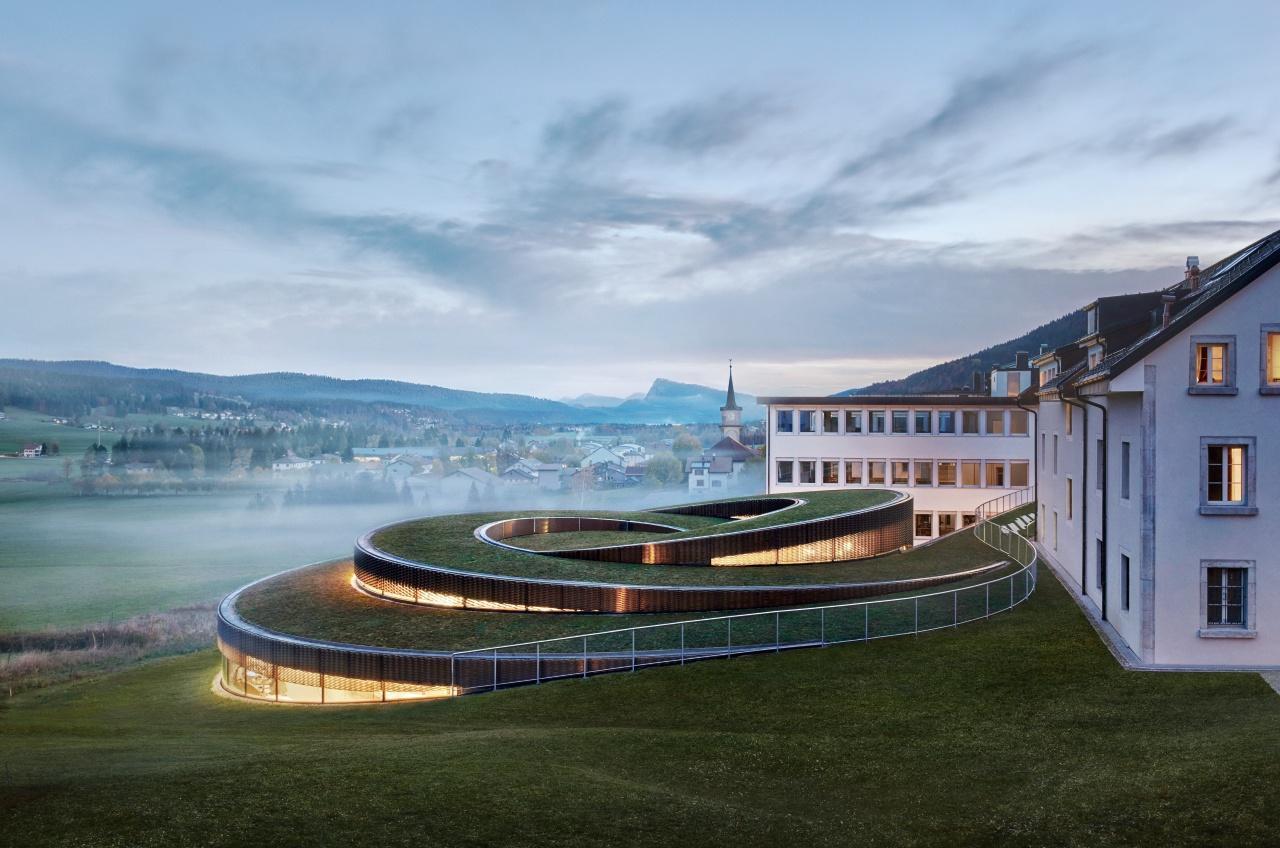 AP博物館由丹麥建築事務所BIG (Bjarke Ingels Group) 設計，與舊建築連成一氣，融入汝拉山谷的景色之中。