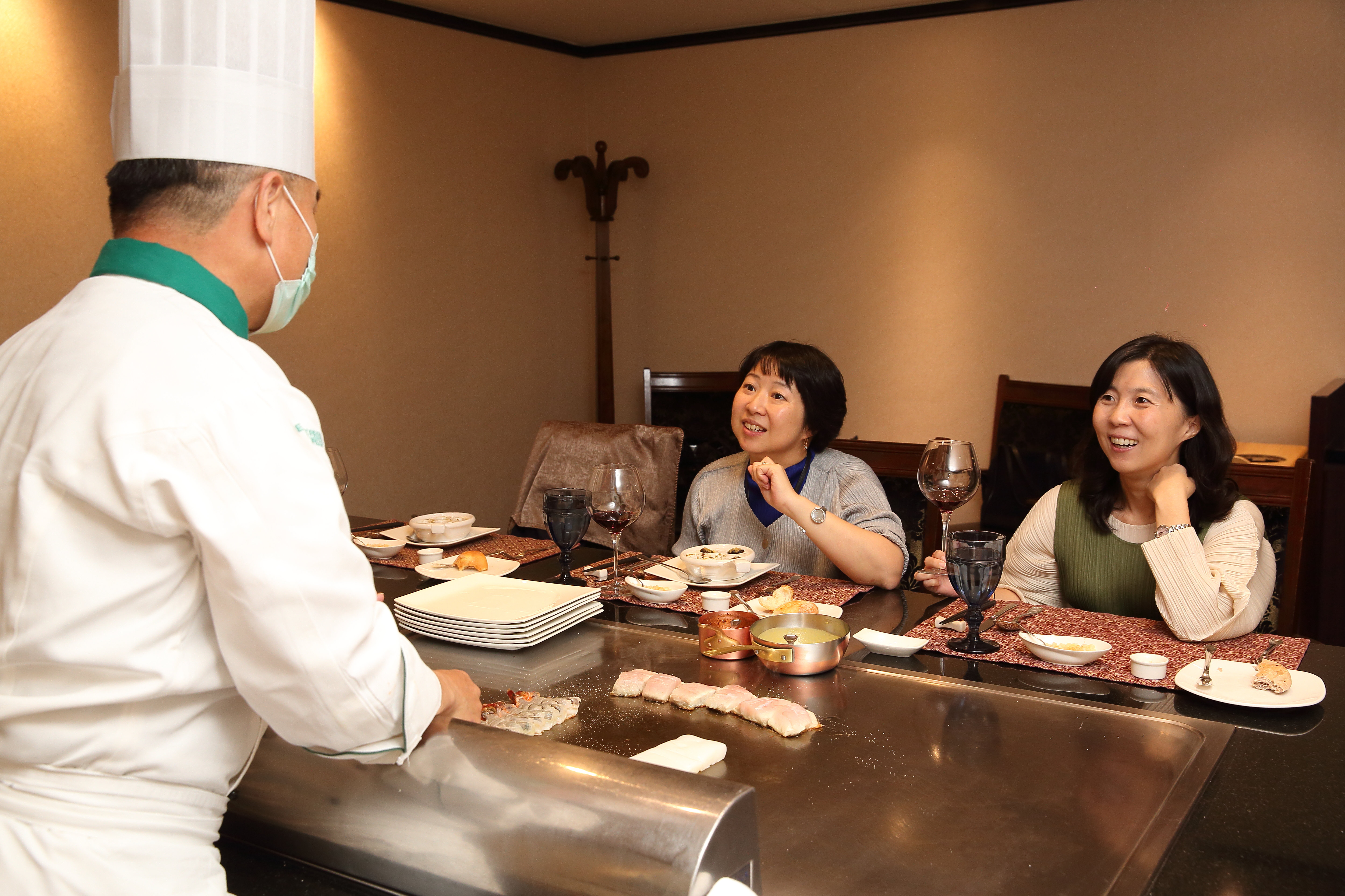 冠品鐵板燒主廚曹茗欽為林佳沛（右）、林玫芸（左）姊妹重現當年父親熱愛的鐵板美食。