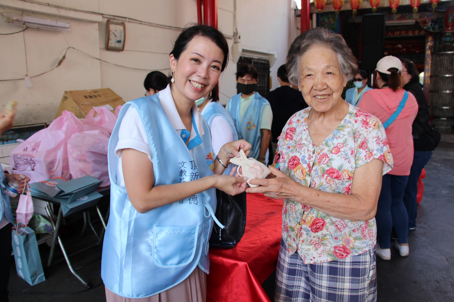 頂新和德文教基金會副執行長蕭巧怡發送中草藥香包給村民。（頂新和德文教基金會提供）