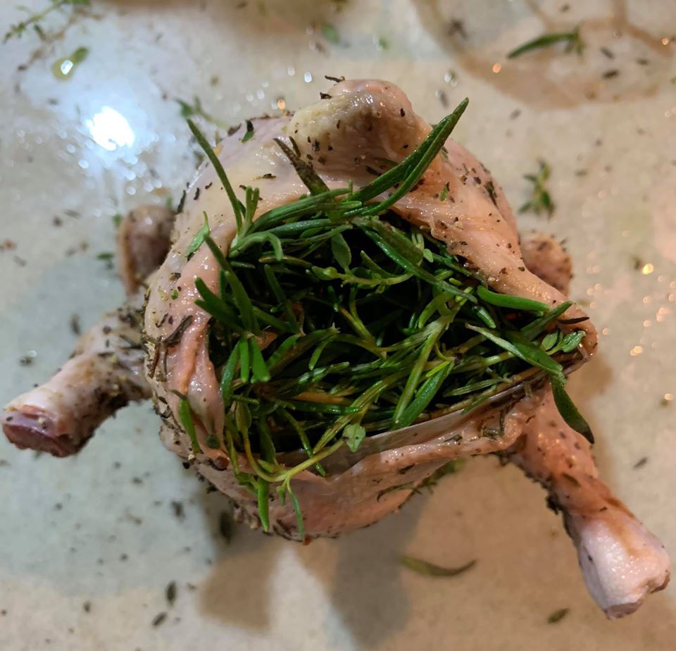 將春雞腹腔塞満香草，要把肚子塞得鼓鼓的。