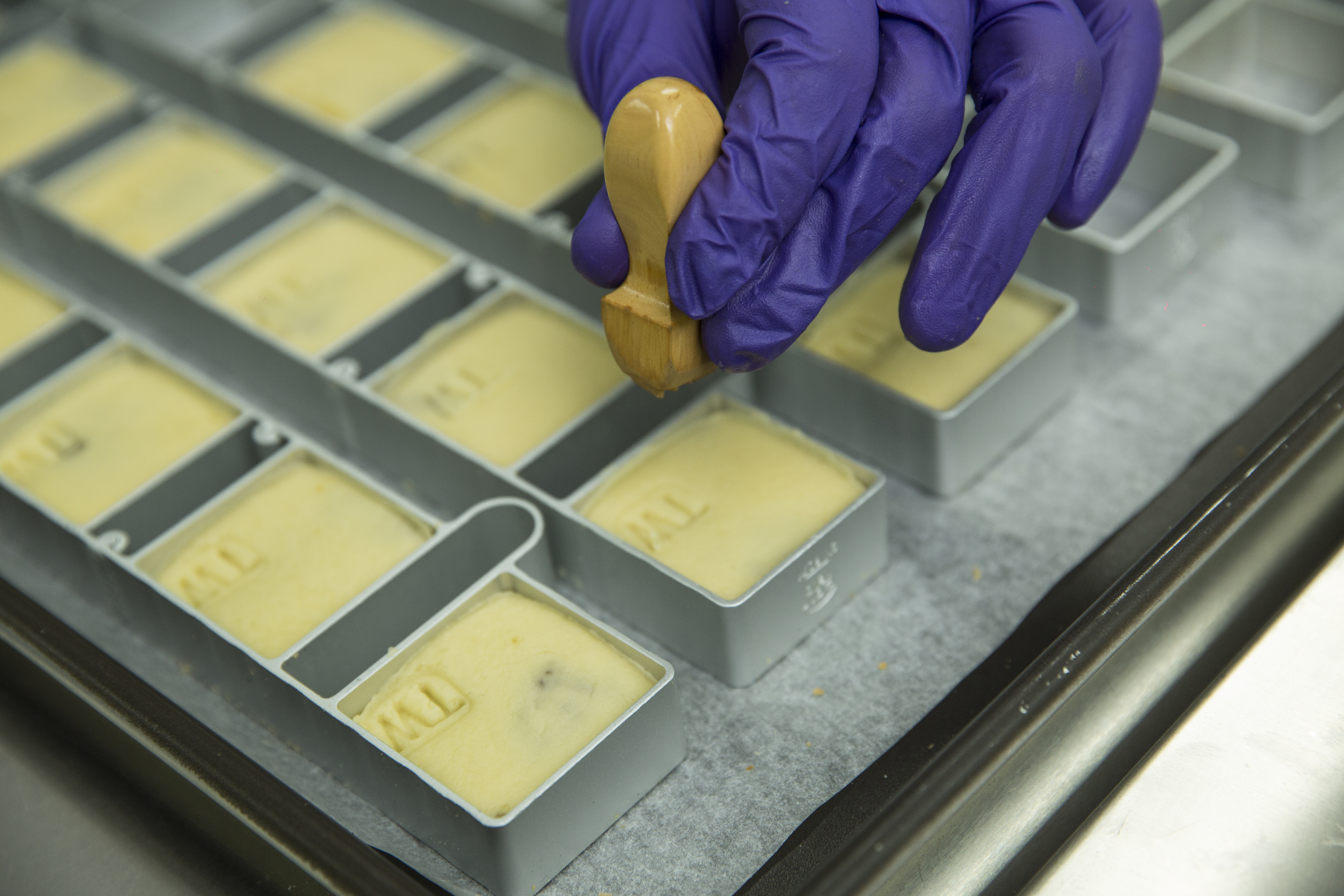 待鳳梨酥送進烤箱前，高吉良都會拿出特製的「TW」印章蓋上，他說：「我要讓人家在世界各地吃到，就知道它就是來自台灣。」