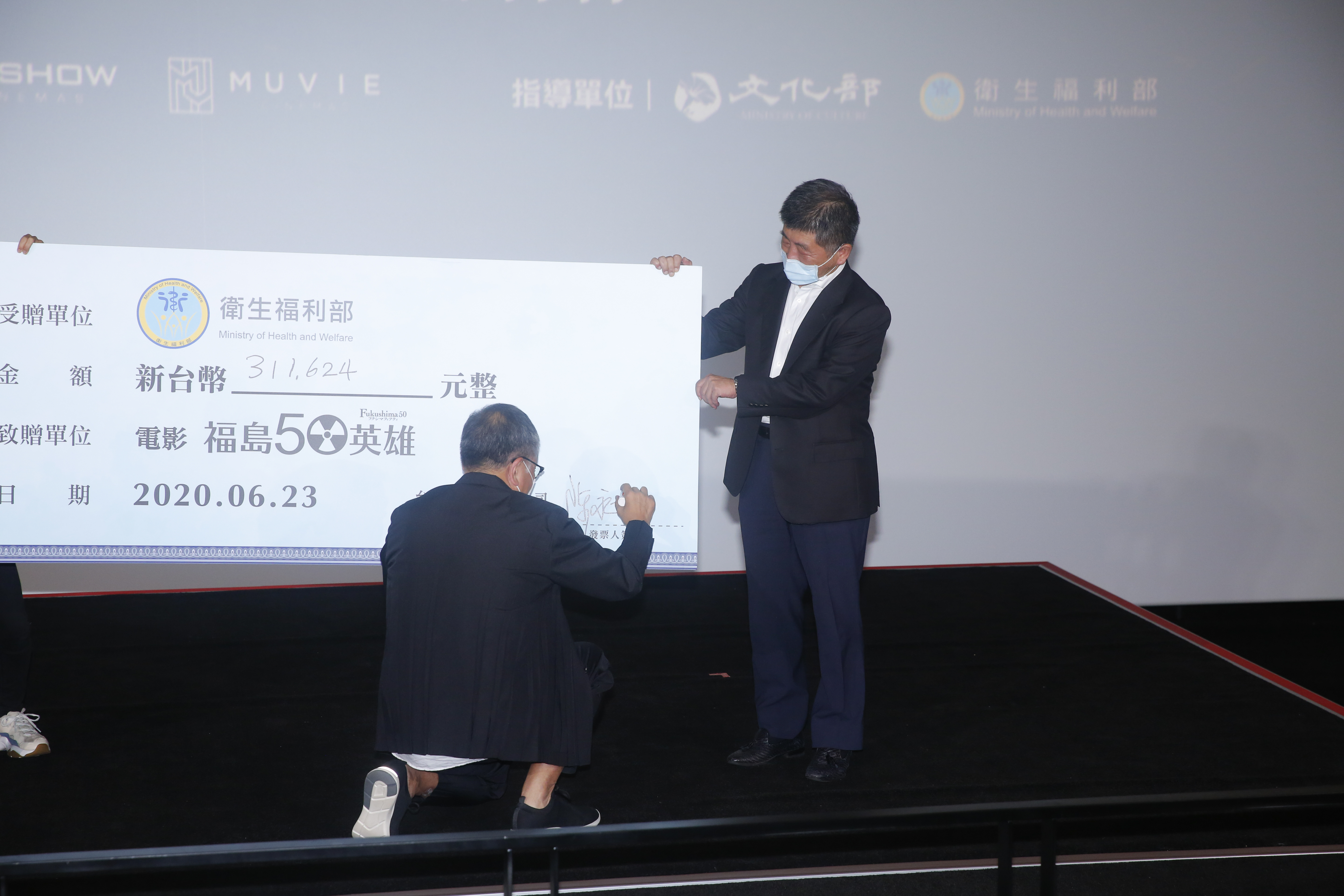 經衛福部陳時中部長提醒，双喜電影總經理陳永雄阿莎力立刻拿筆在支票簽下大名。