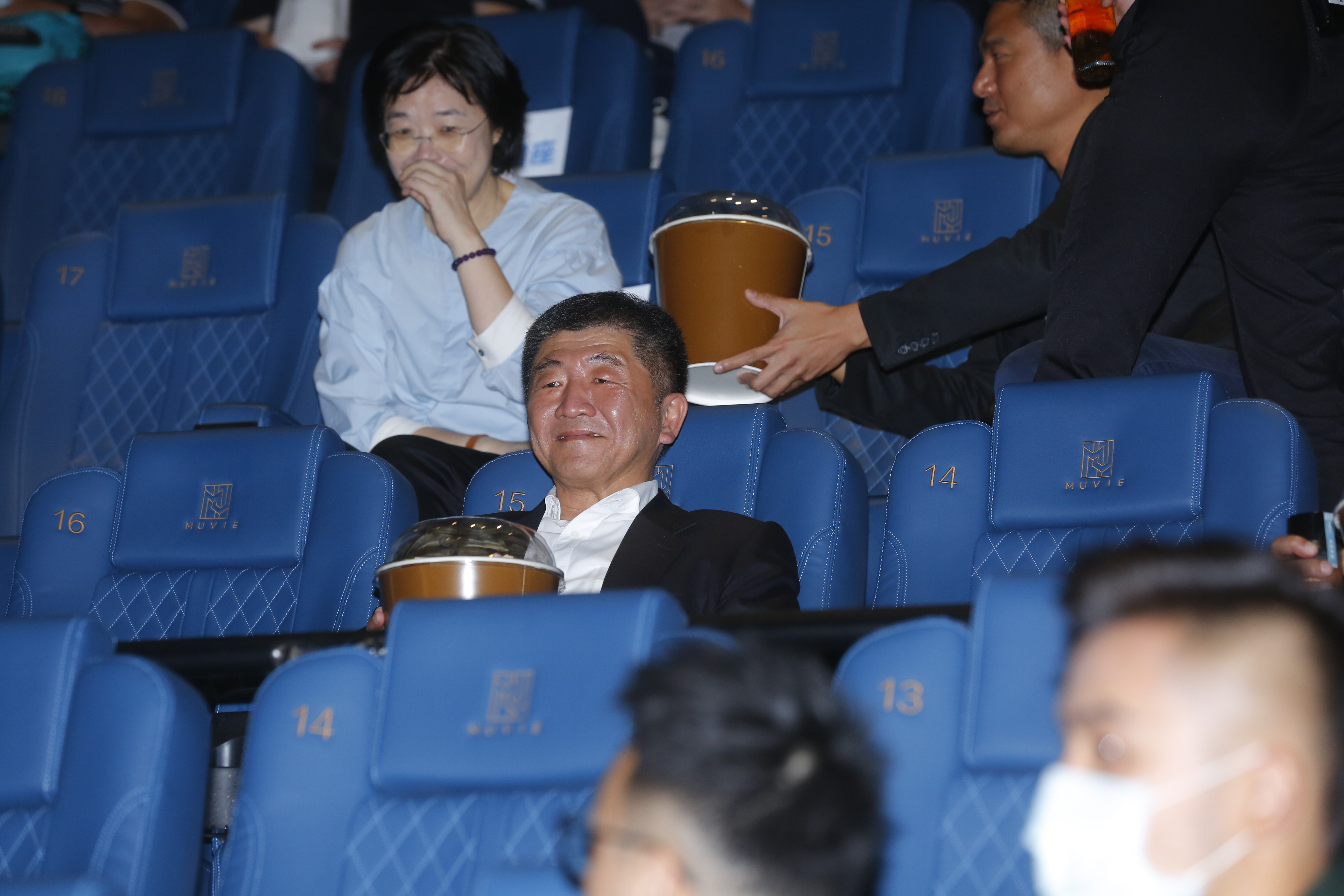 衛福部陳時中部長抱著大桶爆米花示範在看電影時保持社交距離的安心吃法。