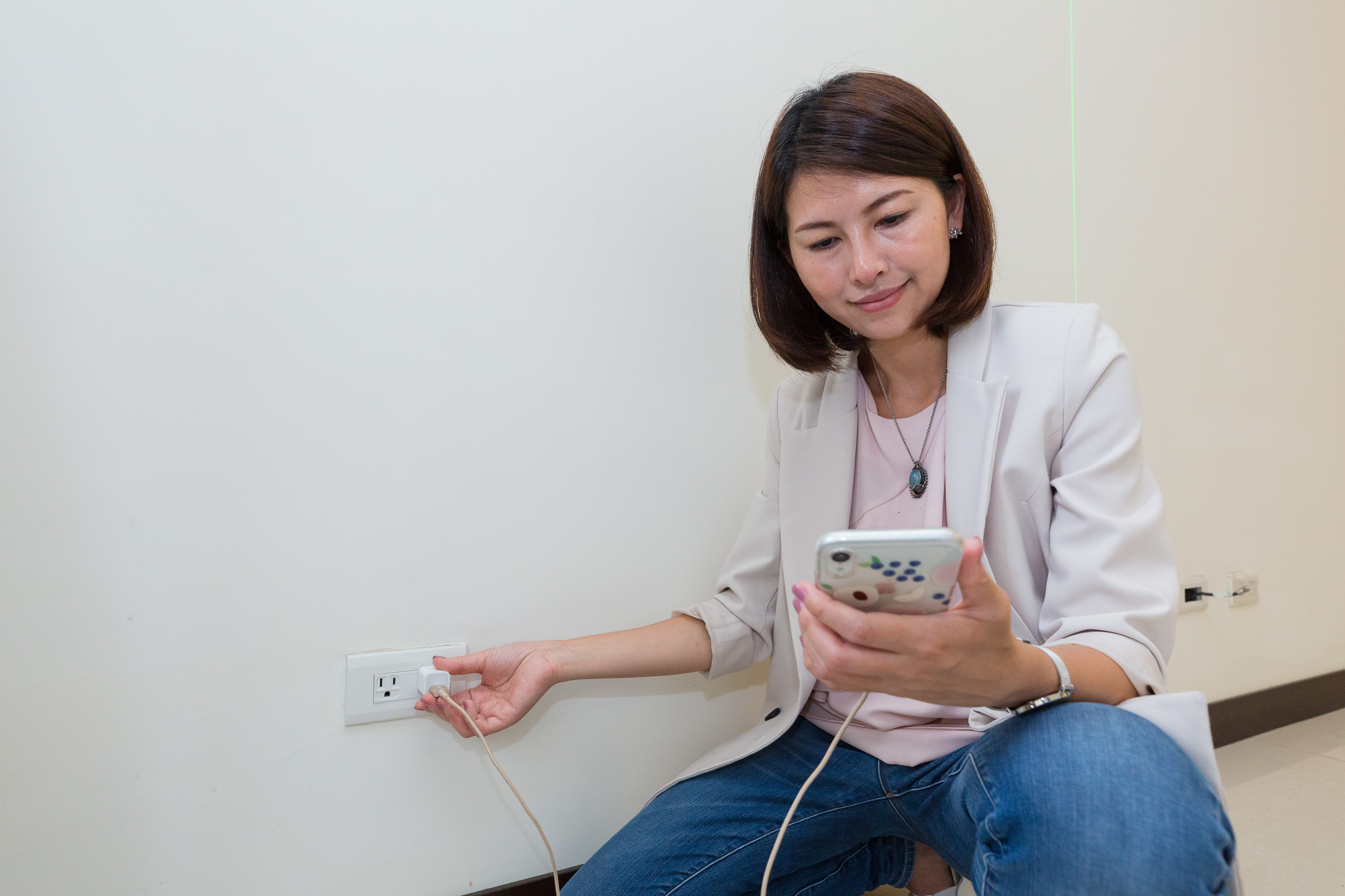 驗屋時，可以自備手機充電插座來測試插座是否能正常運作。圖為House123執行長邱愛莉。