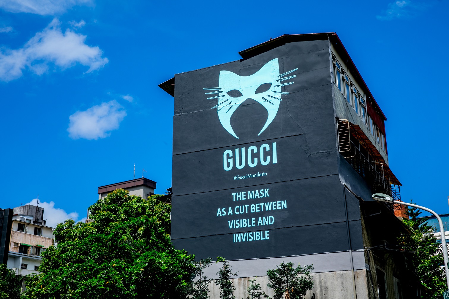 2019年7月 Gucci宣言–MANIFESTO：以全新潮流之姿，Gucci推出特別系列，紀念秋冬時裝秀背後的動人靈感與驚豔才思：Gucci宣言 – MANIFESTO。在藝術牆中亮相了「面具」圖騰，並繪製了源自時裝秀專題文章、探討時裝秀文化內涵的特色標語。從始至終，凸顯了一條關鍵資訊：「THE MASK AS A CUT BETWEEN VISIBLE AND INVISIBLE（面具是隱秘的內裡與表層之間的一道屏障）。」（GUCCI提供） 