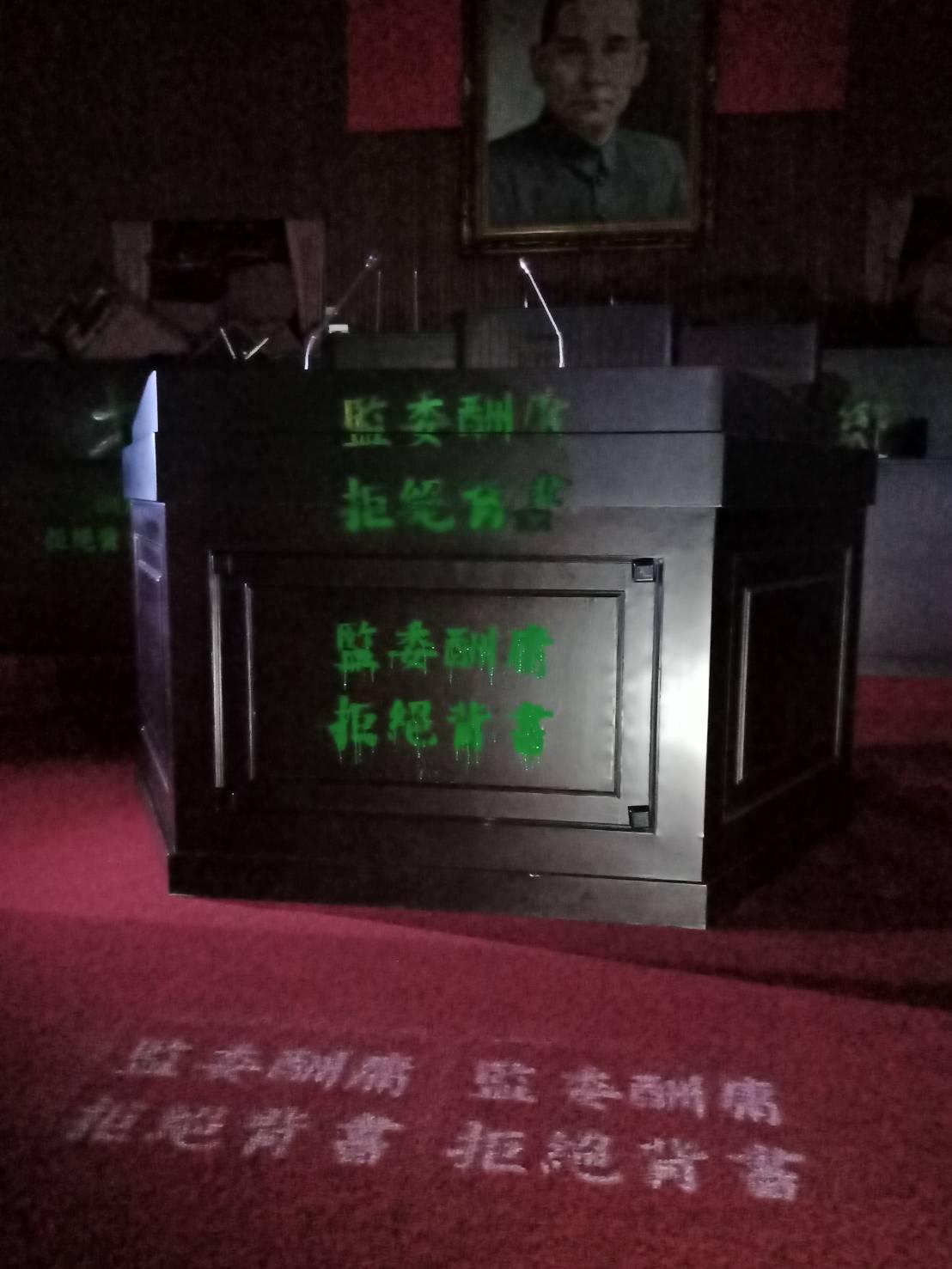 20名藍委今破門佔領議場，在場內噴漆「監委酬庸，拒絕背書」字樣抗議。（國民黨團提供）