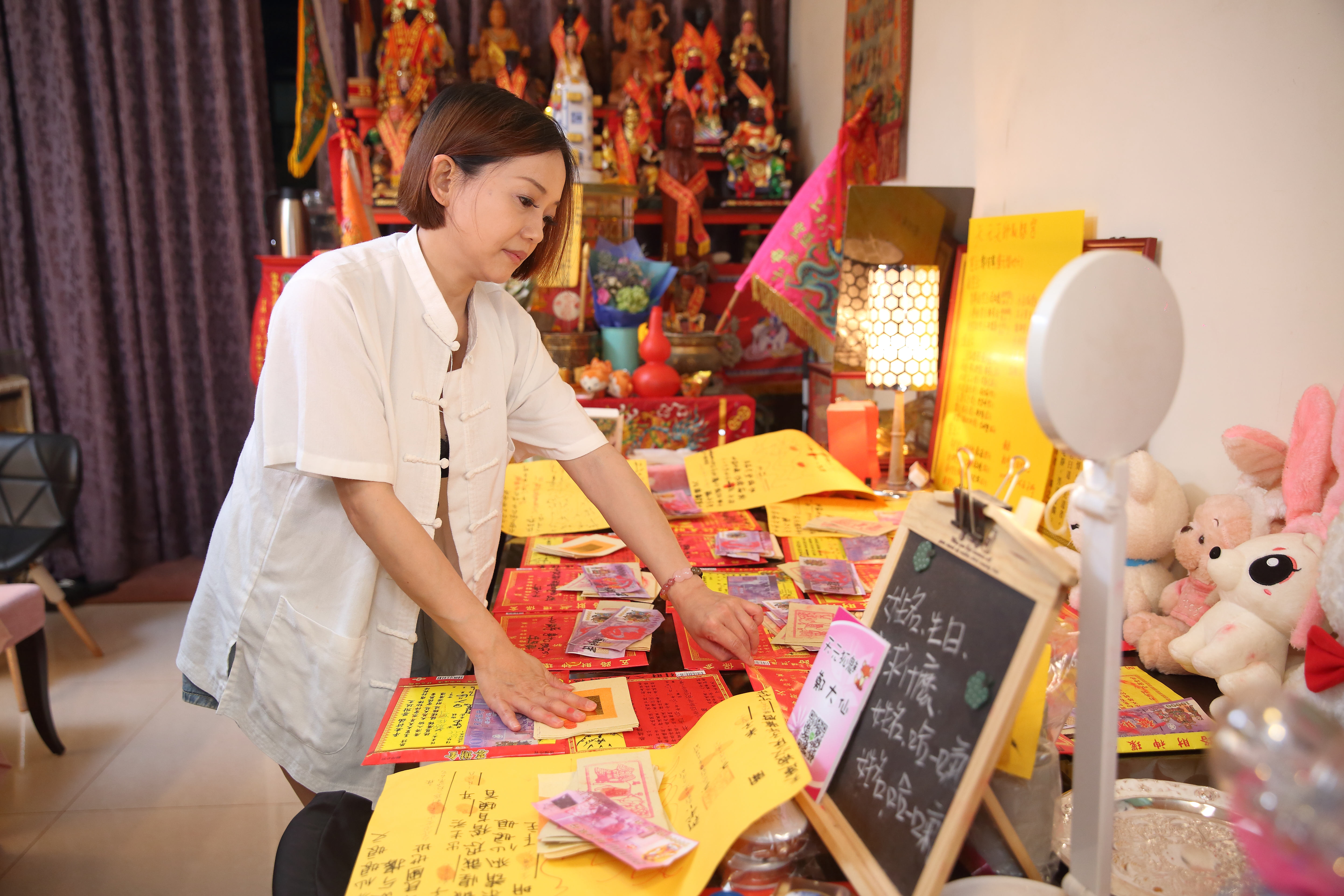 鄭安室仔細整理長桌上酒店小姐們補財庫的金紙。