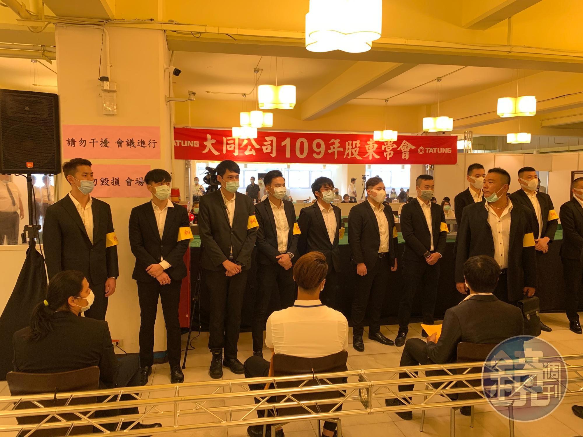 股東會現場站滿一排黑衣人。