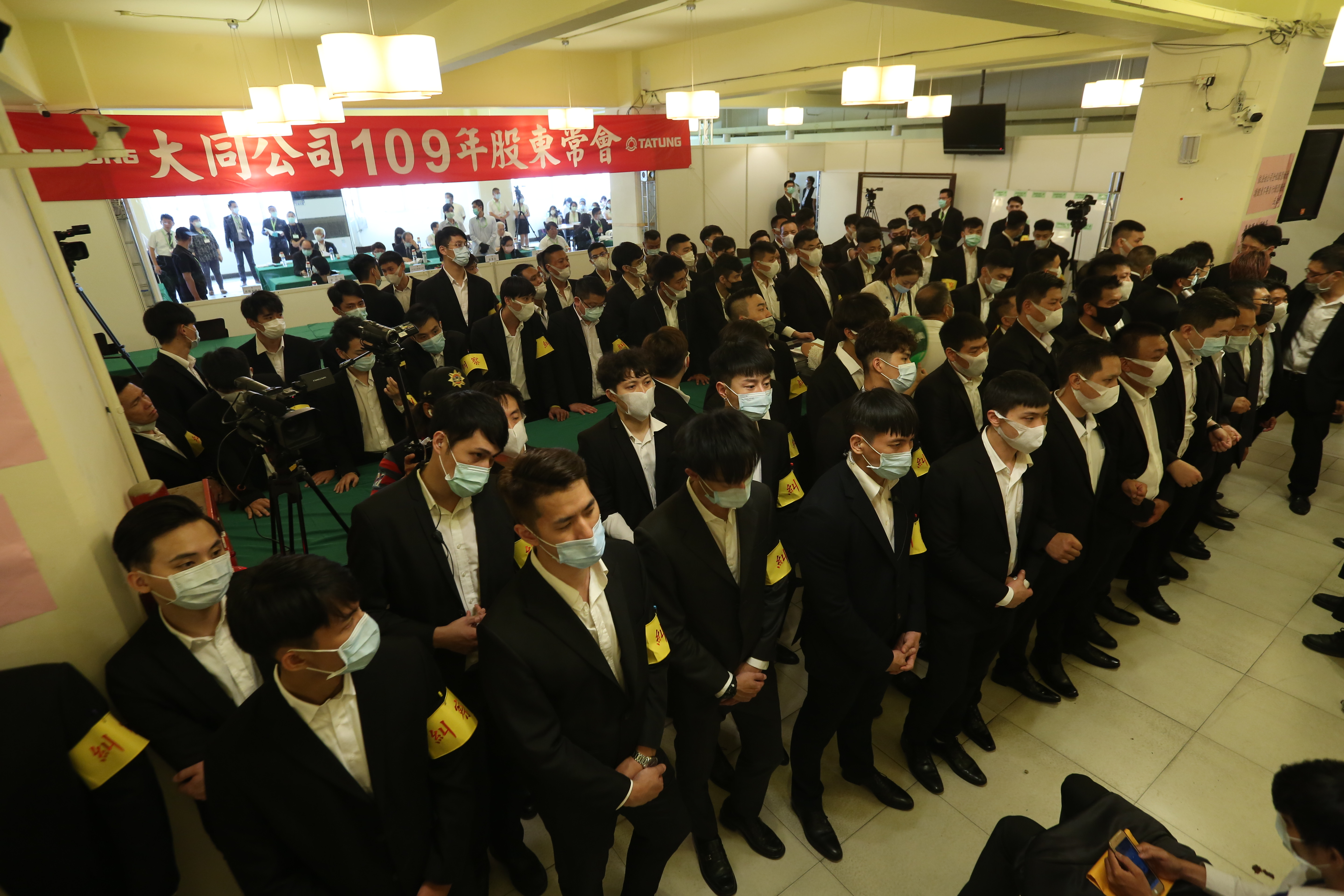 公司派找來大批黑衣人士圍住主席台，導致現場無法看到計票狀況。