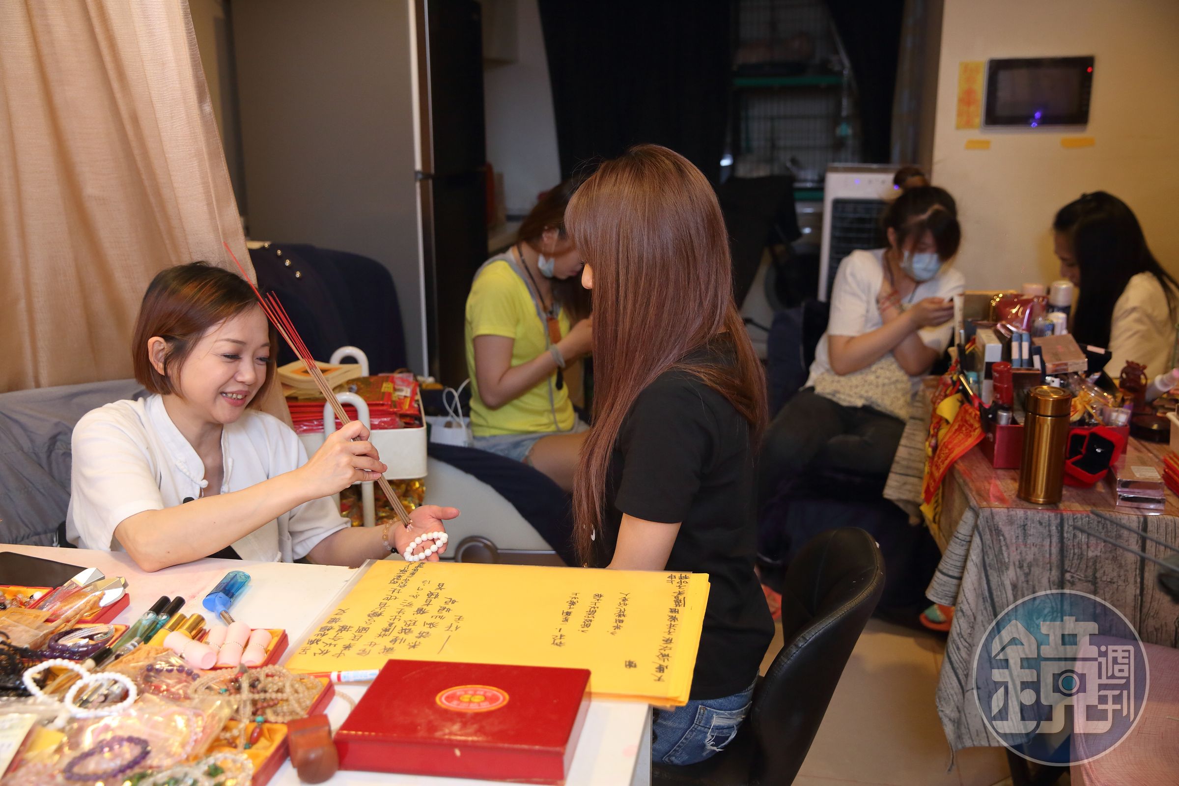 接近晚上8點，店裡已擠滿酒店小姐，大家除了在上班前來找鄭安室加持開光畫魅符，也互相打氣要拚第一。