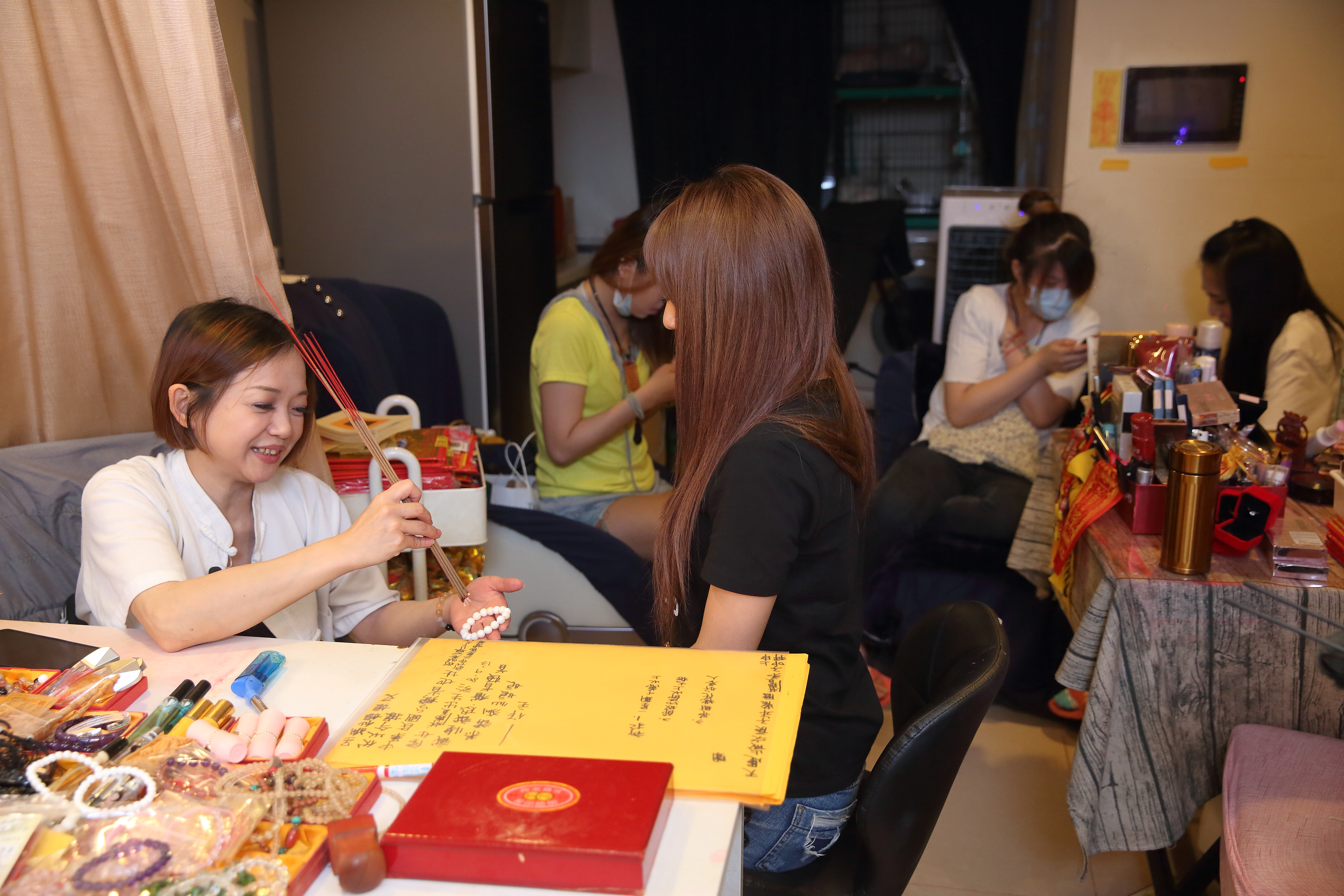 接近晚上8點，店裡已擠滿酒店小姐，大家除了在上班前來找鄭安室加持開光畫魅符，也互相打氣要拚第一。