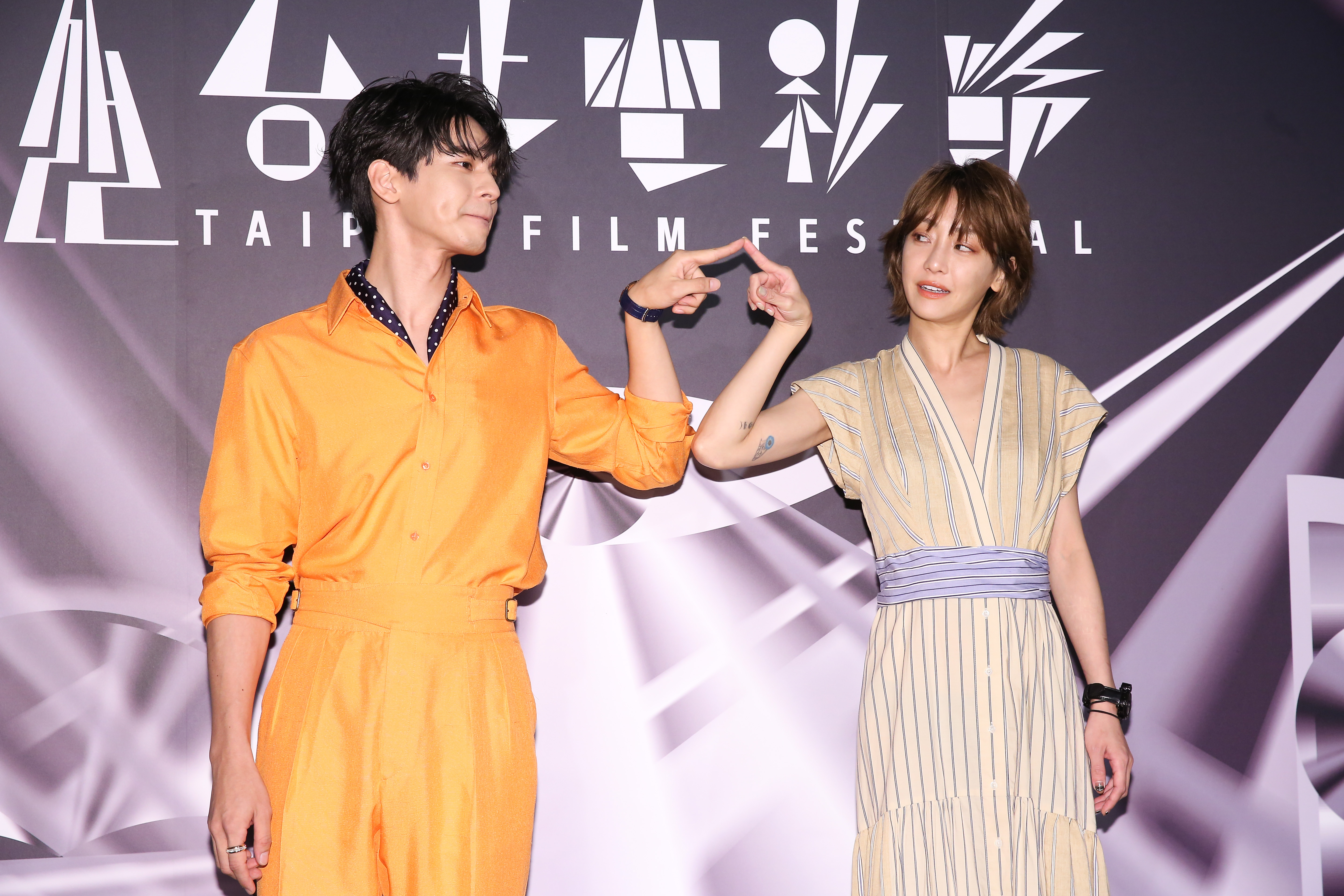 林柏宏（左）、謝欣穎（右）以《怪胎》片中有強迫症患者的身份，舉出手指合影。