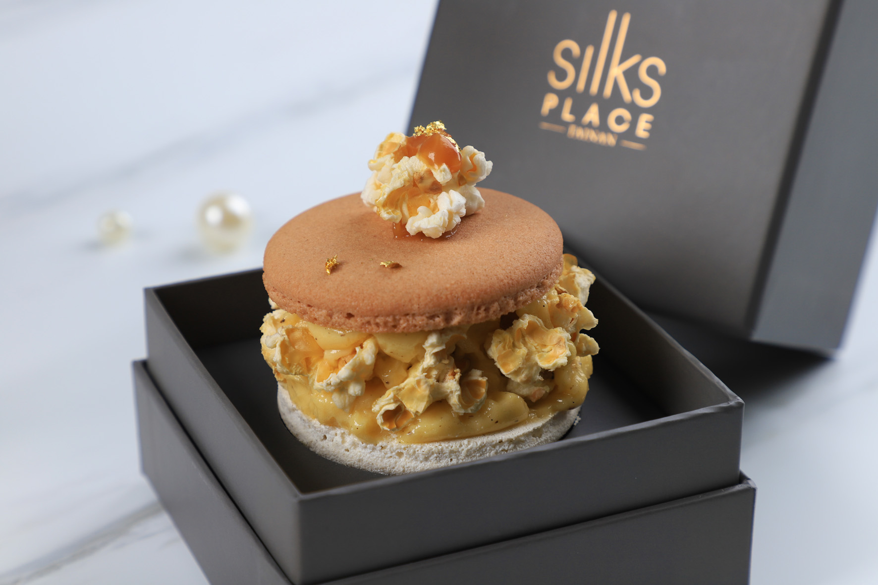 「爆爆胖卡」在咖啡焦糖奶油餡外，綴上酥脆的鹹甜爆米花，像極了一團軟綿的雲朵。（200元／顆）（台南晶英酒店提供）