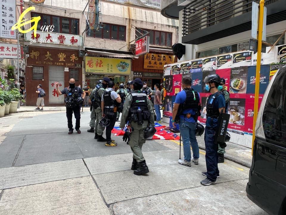 香港男子被警方搜身發現持有數面「中華民國」國旗,被依「涉嫌違反港區國安法」當場被警車抓走。(翻攝自YKS至尊寶臉書)