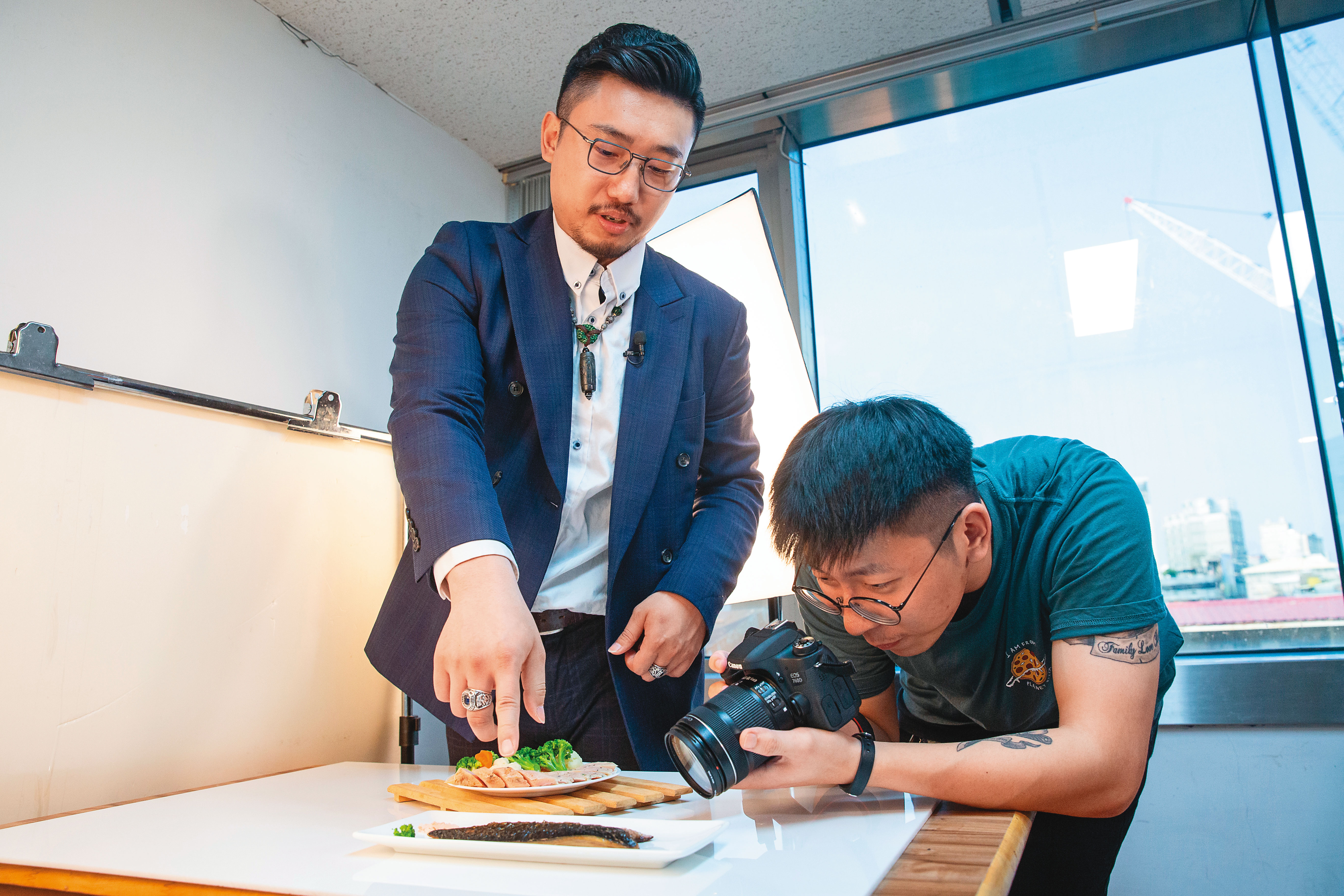 張佑承（左）指導同仁拍攝照片角度，會決定產品看起來是否美味。
