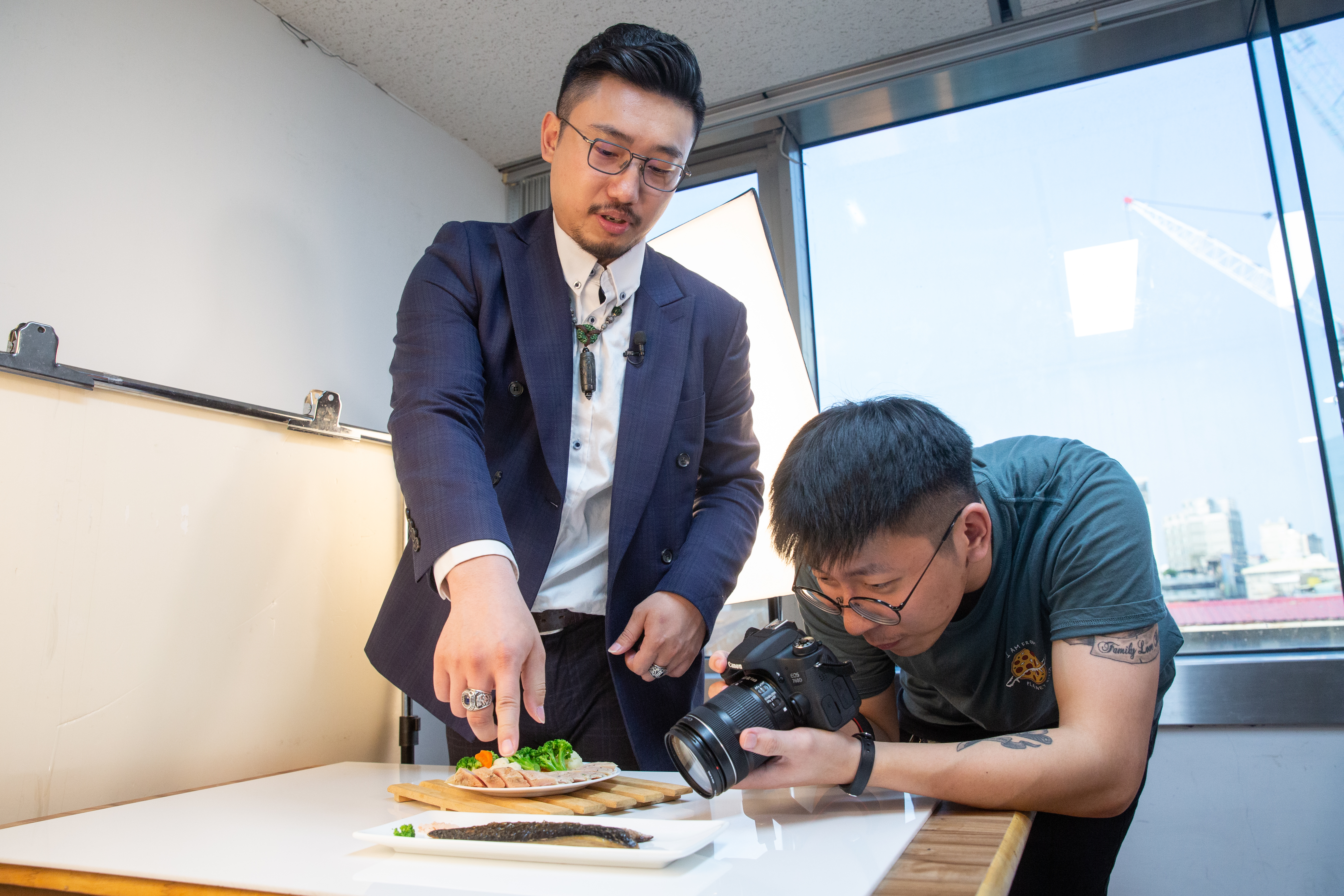張佑承（左）指導同仁拍攝照片角度，會決定產品看起來是否美味。
