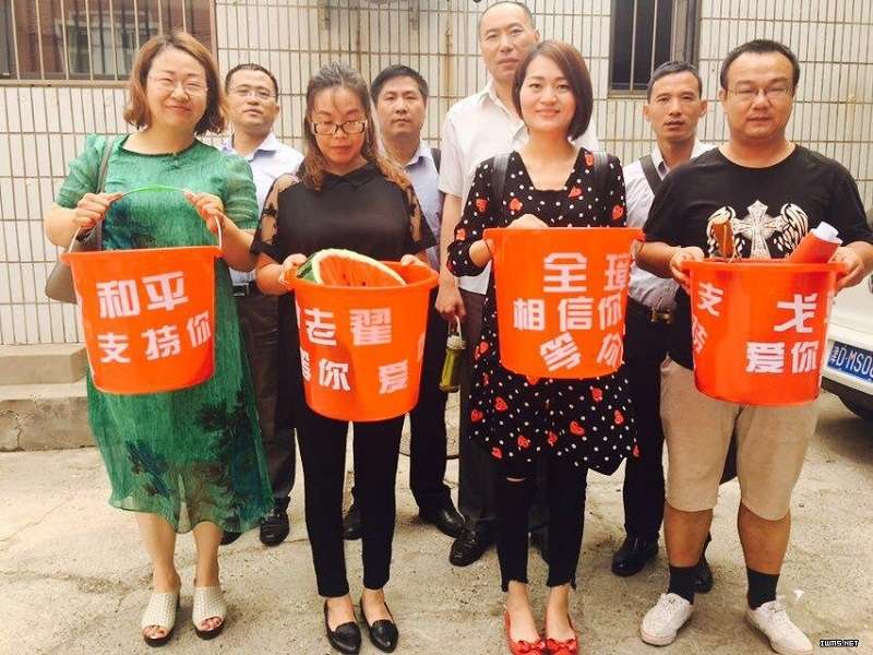 709家屬們以創意發想行動，引起國際關注，圖為她們將丈夫名字印上紅色塑膠桶，舉紅桶抗議。（翻攝自李文足twitter）