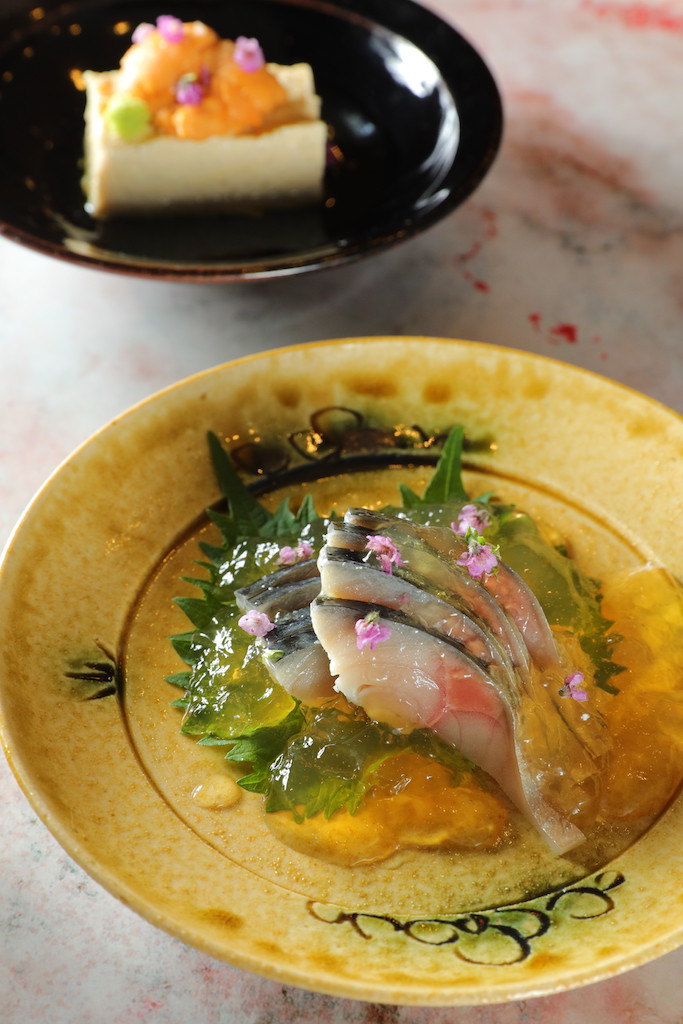 「醋凍鯖魚生魚片」的熟成魚肉綻放旨味（前，580元／份）；「海膽湯葉豆腐」豆香和海鮮味濃郁。（後，390元／份）