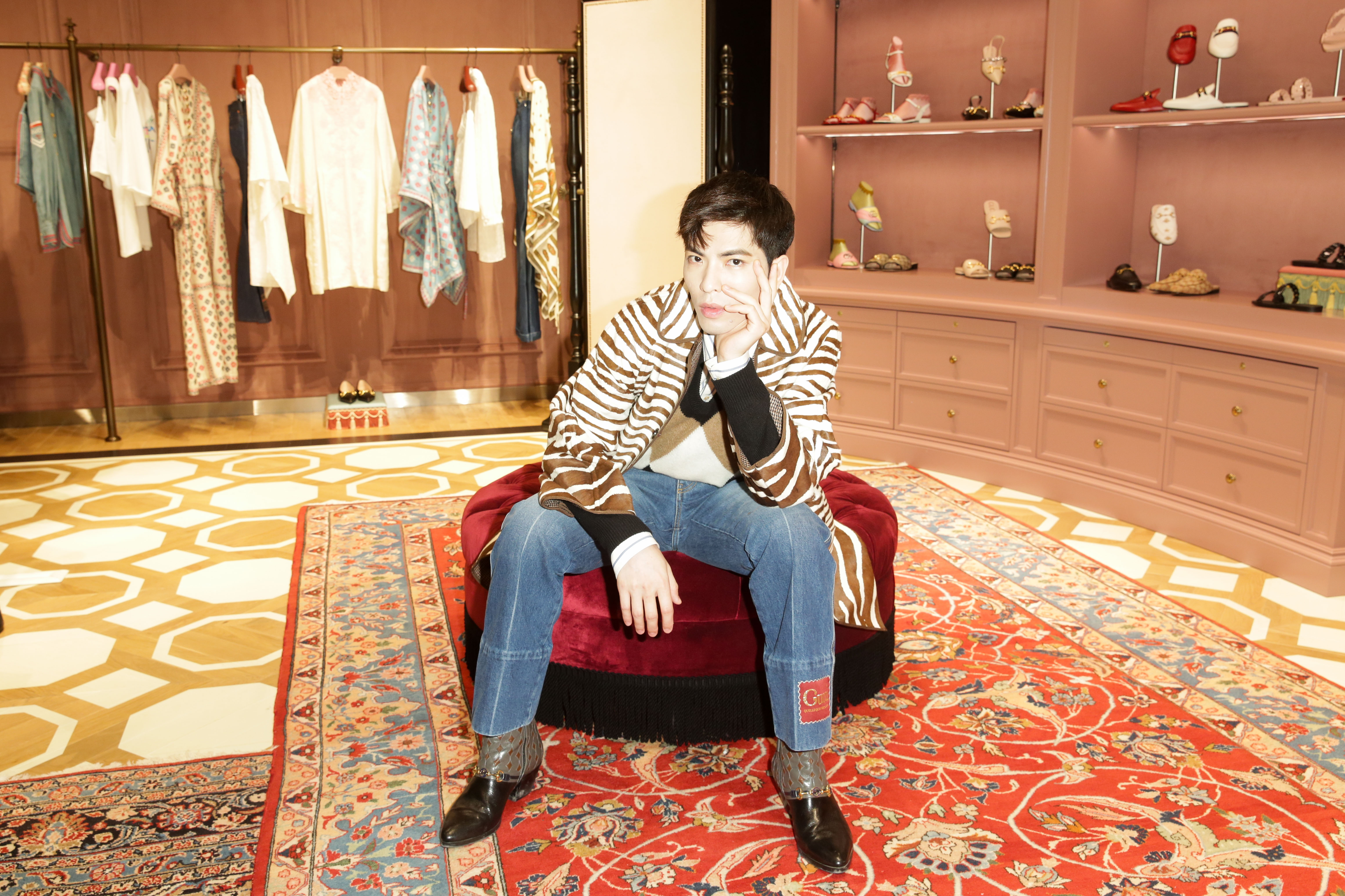 蕭敬騰穿著GUCCI早秋服裝出席開幕活動，斑馬紋印花夾克NT$315,000、菱格紋V領毛衣NT$29,500、條紋襯衫NT$23,500、GUCCI標籤牛仔褲NT$30,000、Horsebit 1955黑色拼接短靴NT$59,100。