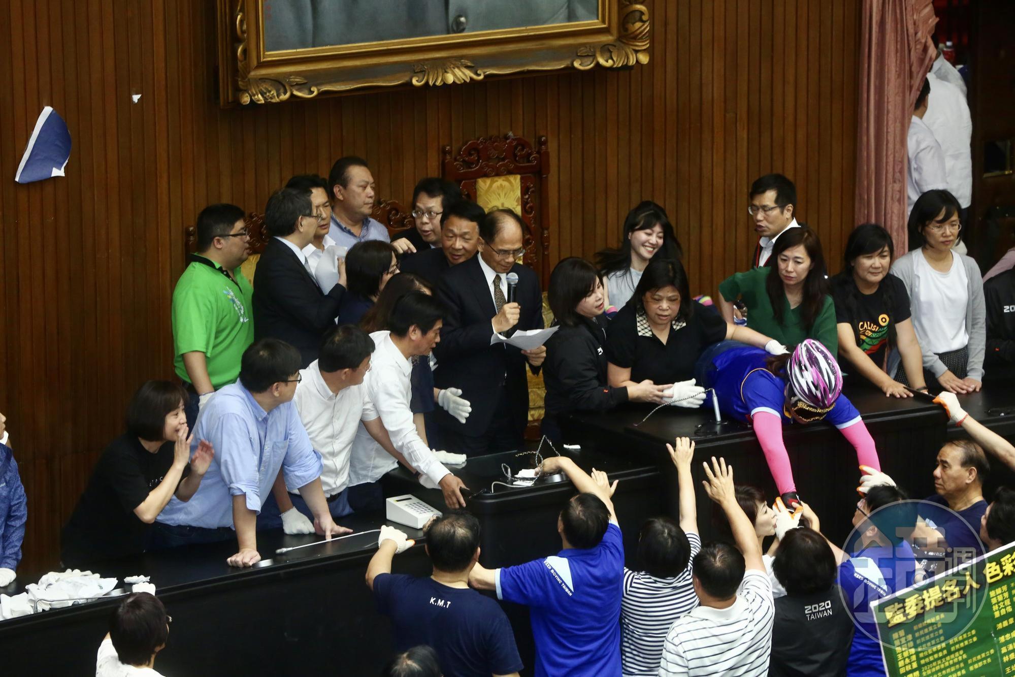 事先就戴好安全帽及護目鏡做防範的陳玉珍，一直死守在主席台上不走。