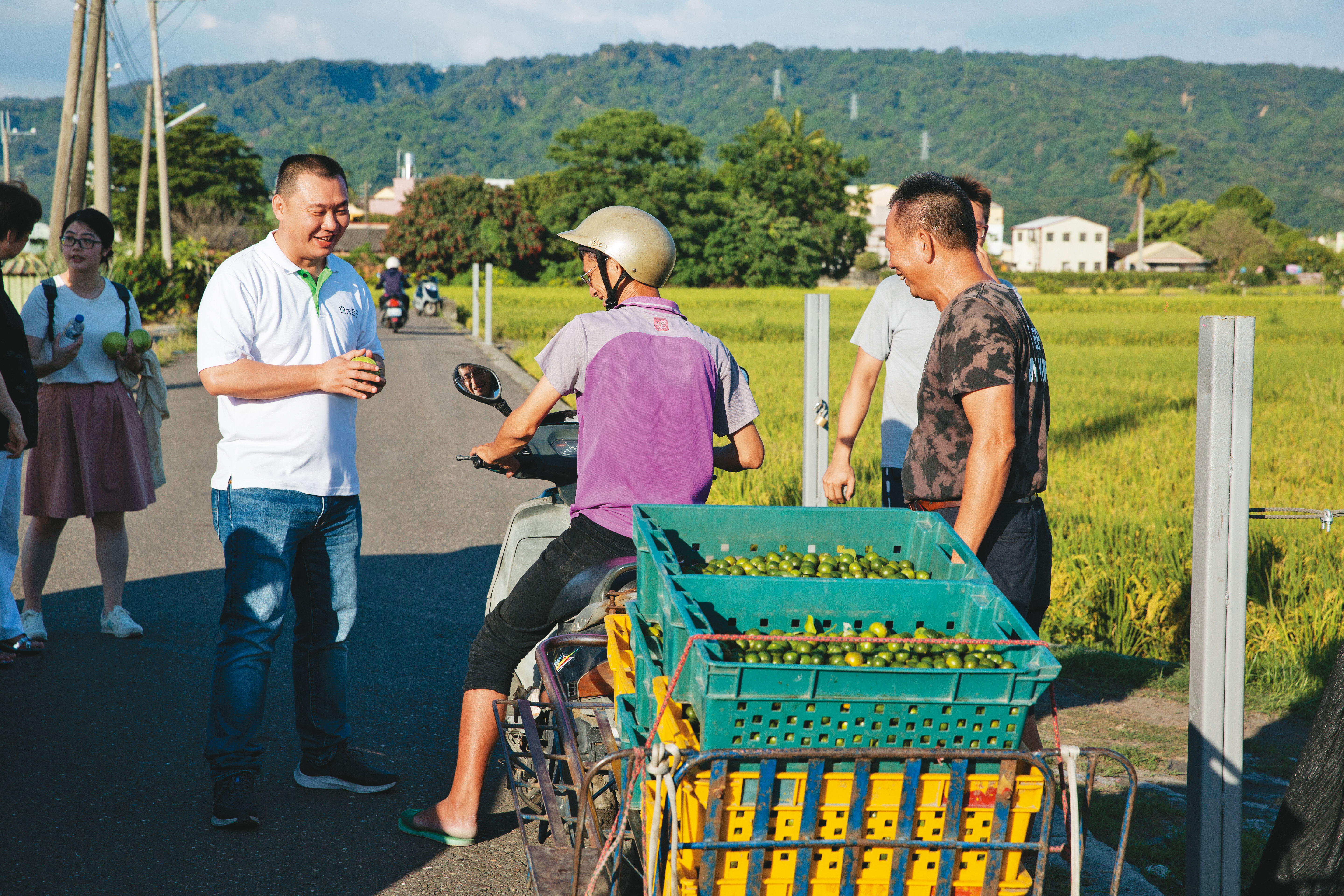 邱瑞堂（左1）重視水果產地經營，他帶我們去社頭看芭樂園，路上恰巧碰到合作金桔果農。