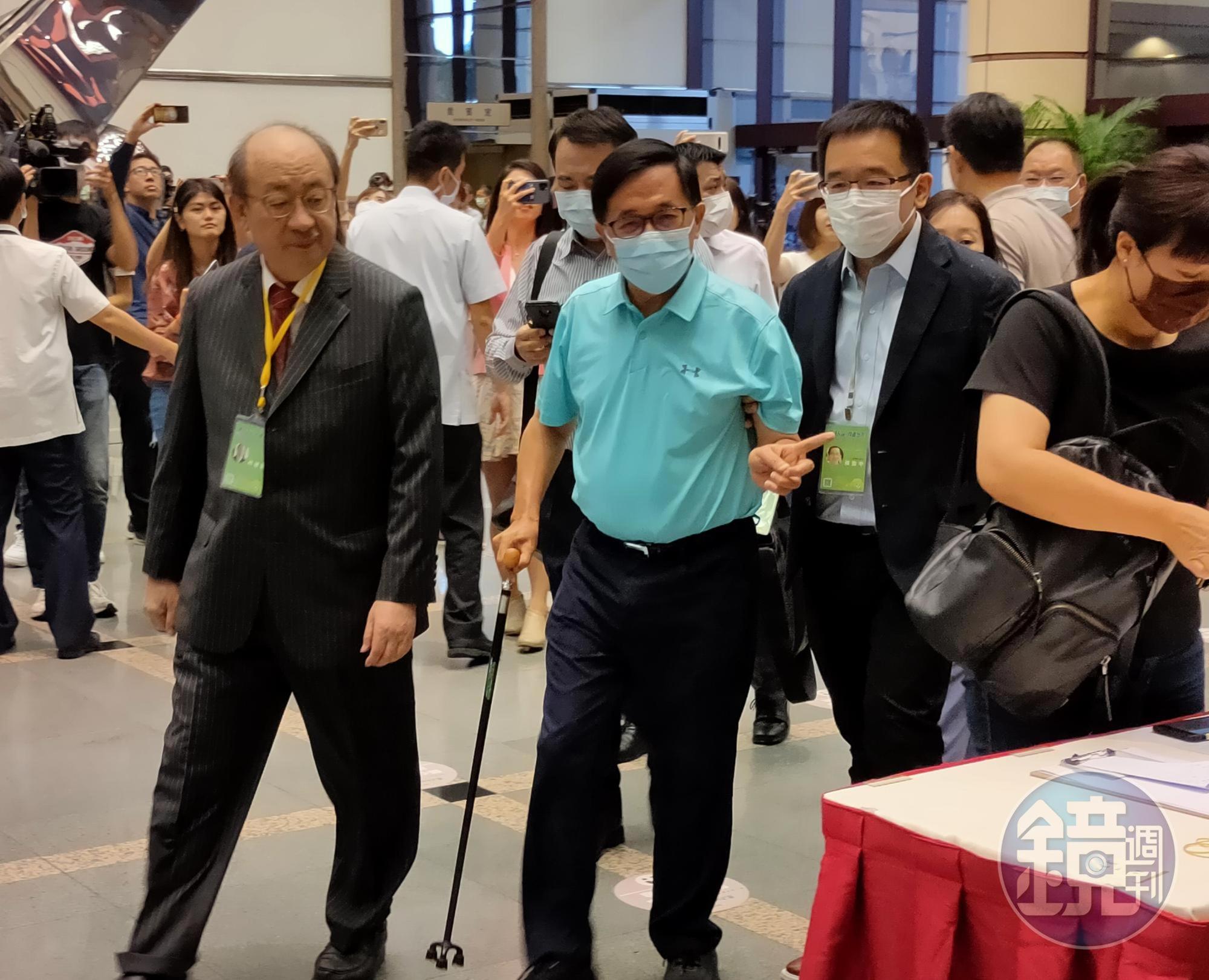 陳水扁戴著口罩、穿著湖水綠POLO衫、西裝褲，右手拄著柺杖，由陳致中攙扶進入會場。