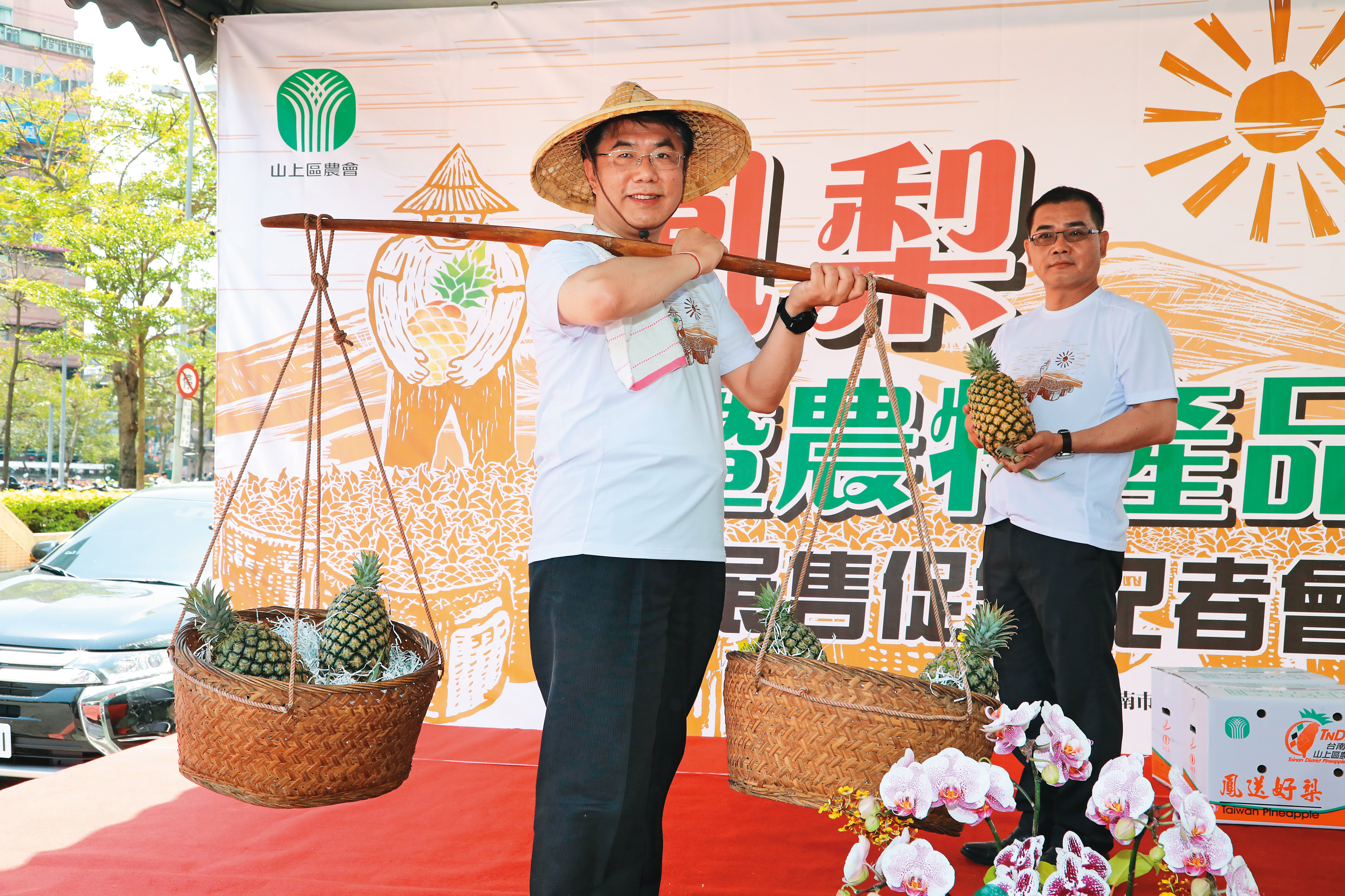 市長黃偉哲戴斗笠，當起「叫賣哥」賣鳳梨，成績嚇嚇叫。（臺南市政府新聞及國際關係處提供）