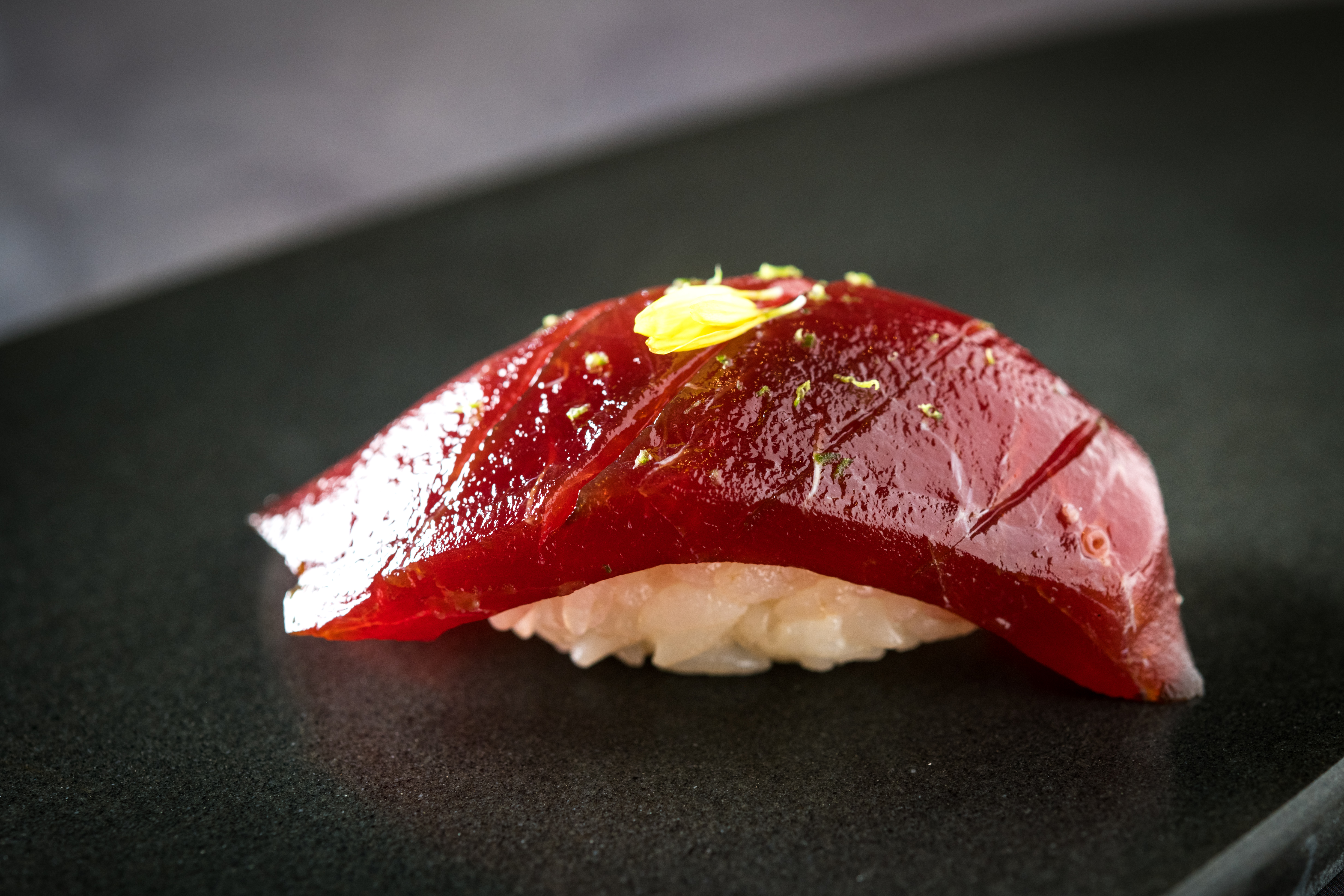 「本鮪握壽司」是用黑鮪魚的背肉，以醬料醃漬後，刨點檸檬皮提味，口感嫩Q甘甜。