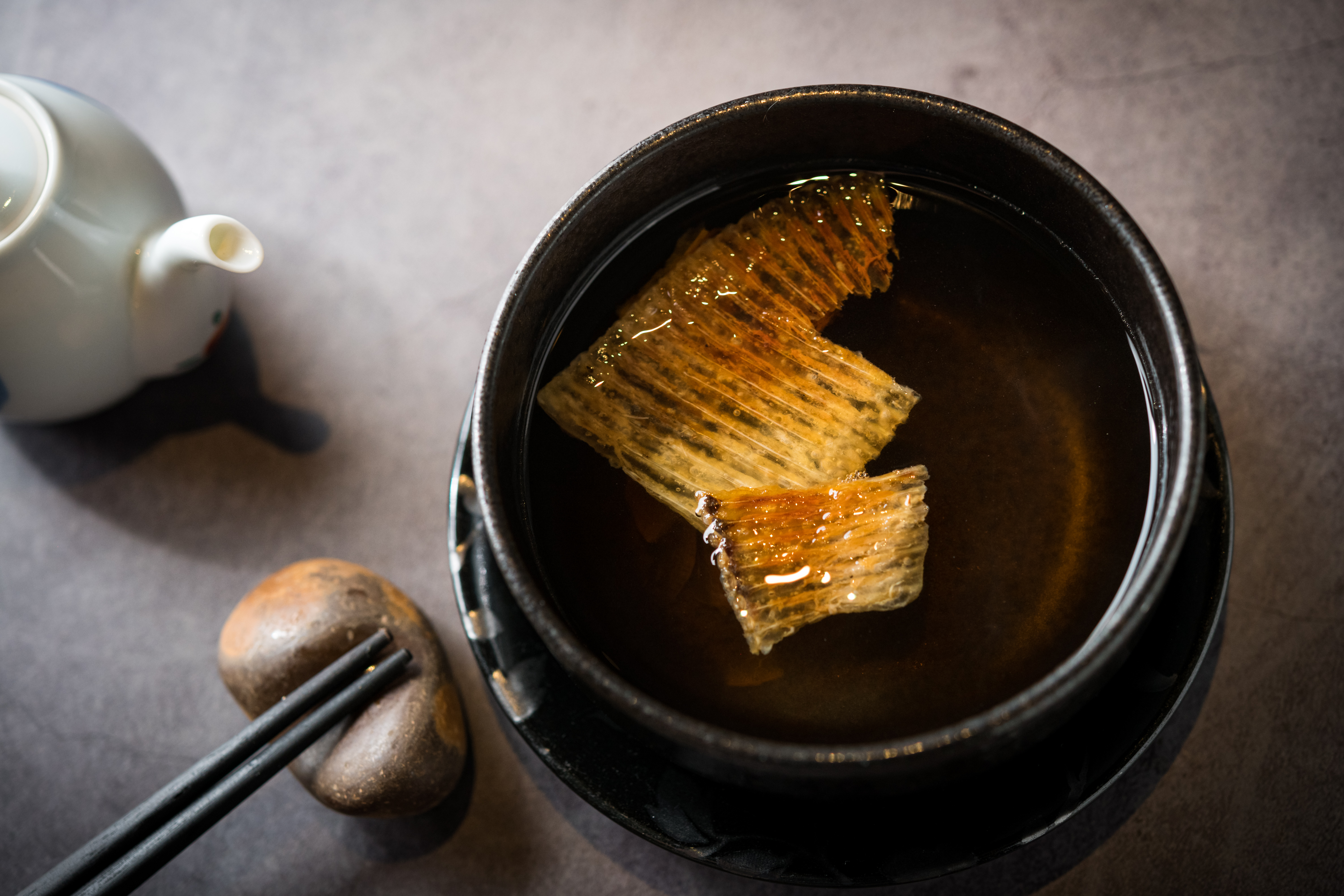 「鮫鰈鰭翅骨湯注」先把鮫鰈的魚鰭烤酥後，沖入柴魚高湯，味道清甜，帶有煙燻和柚子的香氣。