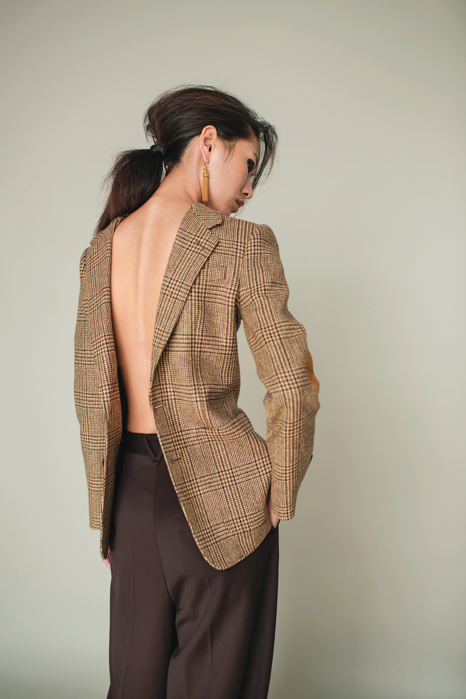棕色格紋西裝外套 NT$87,000 by CELINE／濃咖啡色西裝寬褲 NT$34,900 by BOTTEGA VENETA／Maillons Triomphe金屬黃銅流蘇耳環 NT$28,000 by CELINE