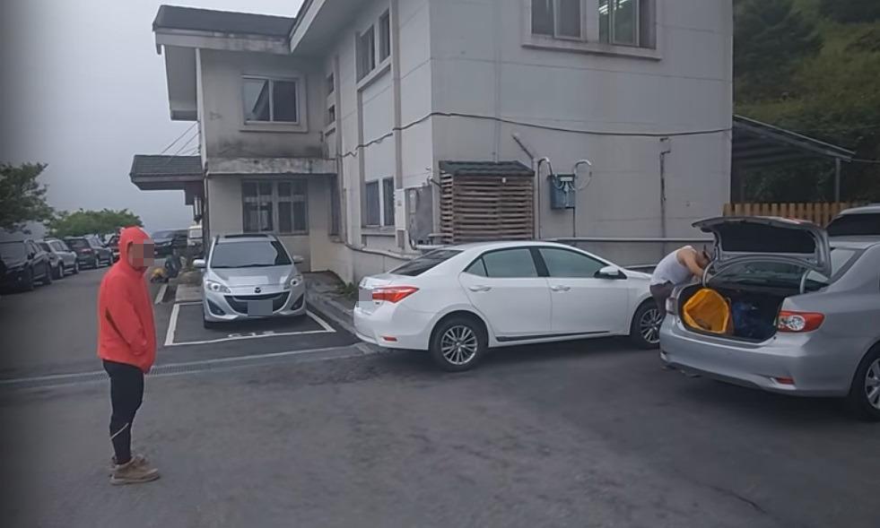 疑似與違停車輛駕駛同行的紅衣山友，在鏡頭前嗆聲。（翻攝自Youtube頻道Kris Loak）