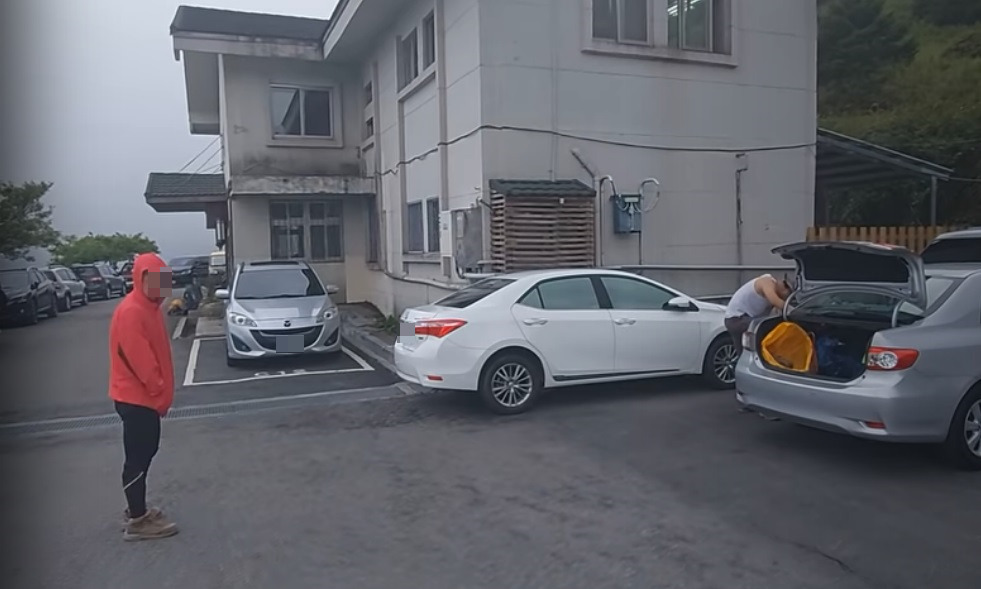 疑似與違停車輛駕駛同行的紅衣山友，在鏡頭前嗆聲。（翻攝自Youtube頻道Kris Loak）