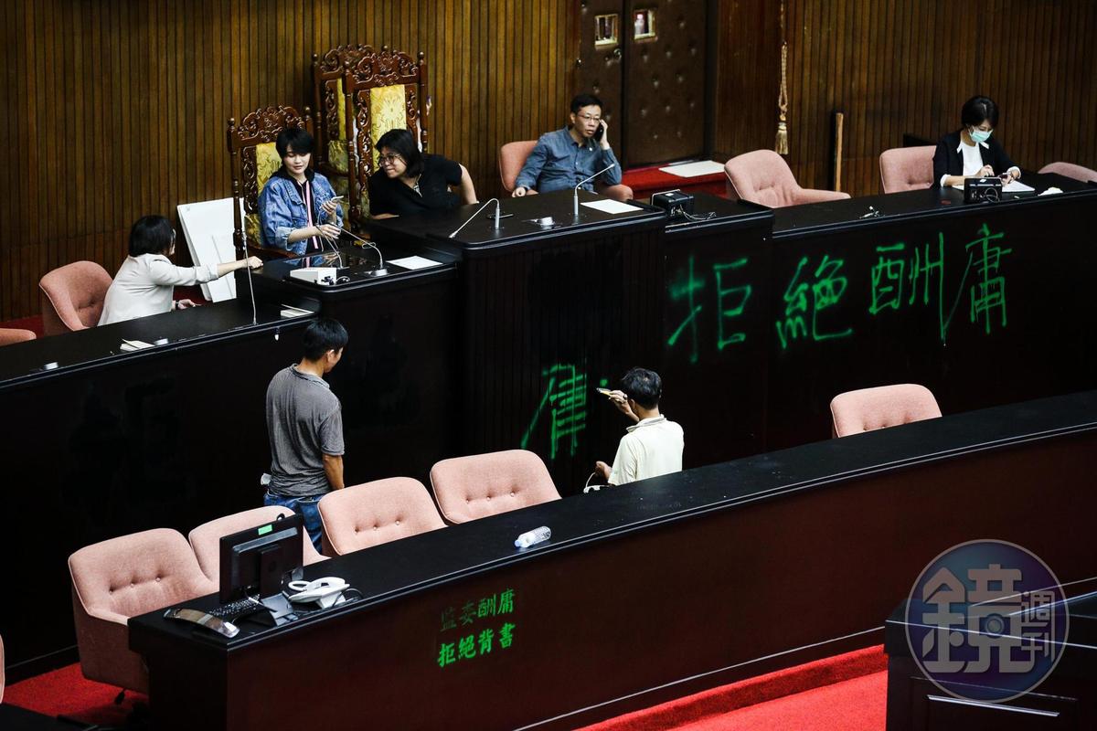6月29日民進黨立委奪回議場後,工作人員修復議場被噴漆的主席台。
