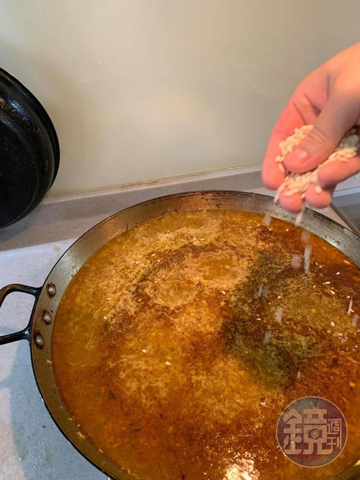 開始在鍋中撒入米粒。