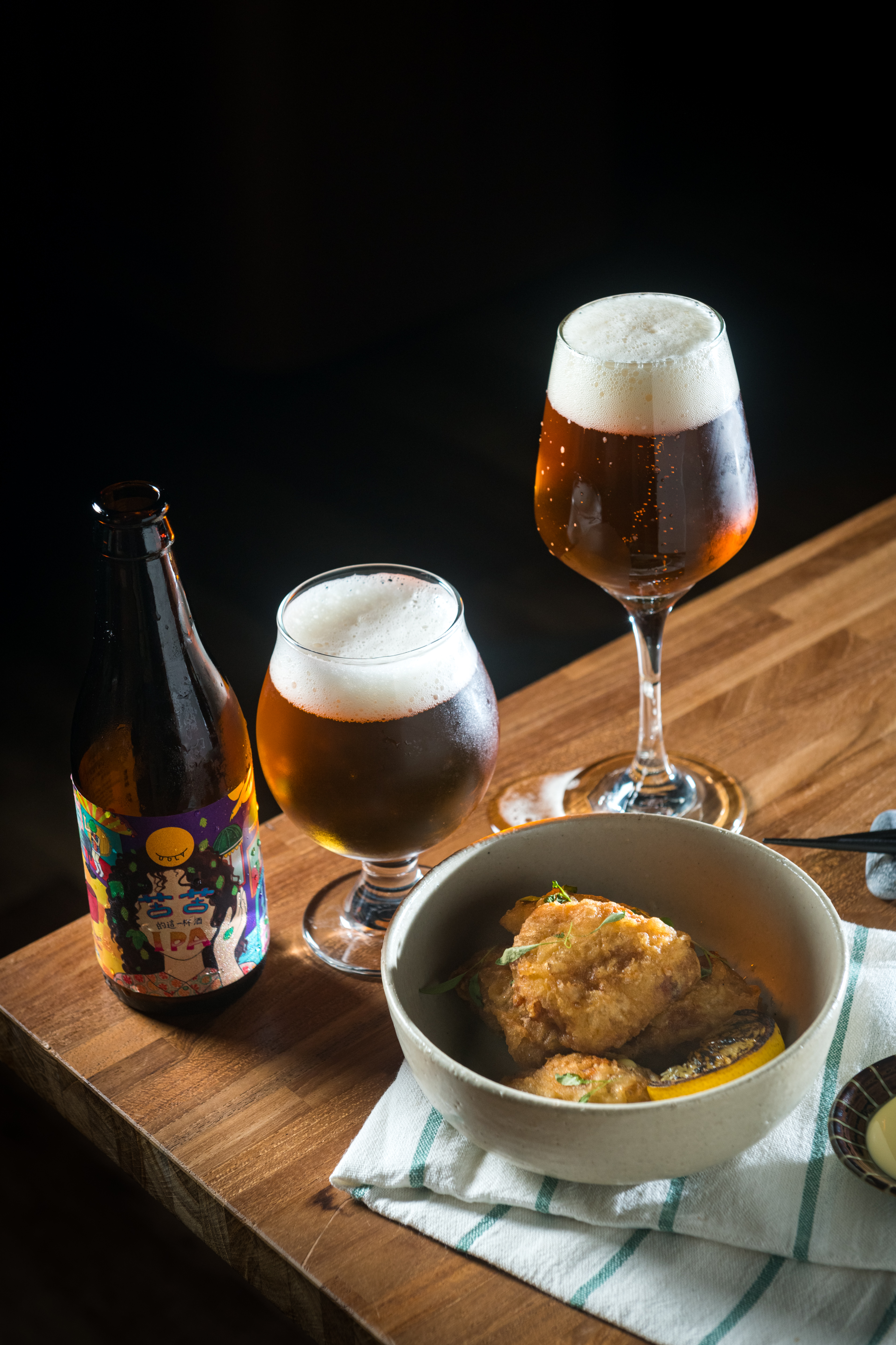 「苦苦IPA」（後，販售店家、價格請洽酉鬼）的苦韻輕柔，和「炸雞翅，柚子胡椒」（前，240元／份）的柚子胡椒，兼具解膩作用。