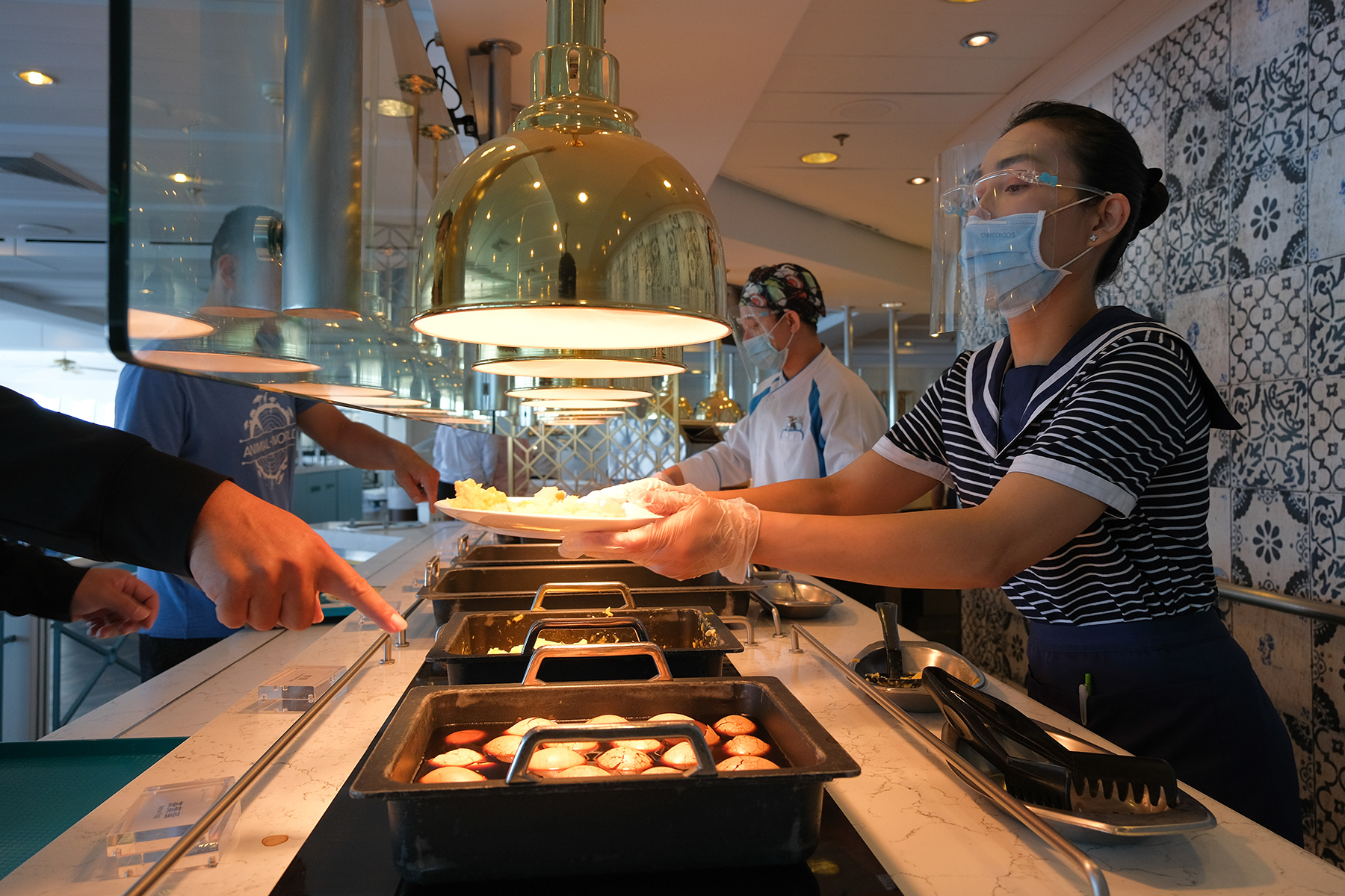 自助餐廳不讓客人自己拿食物，改由服務人員協助夾取。