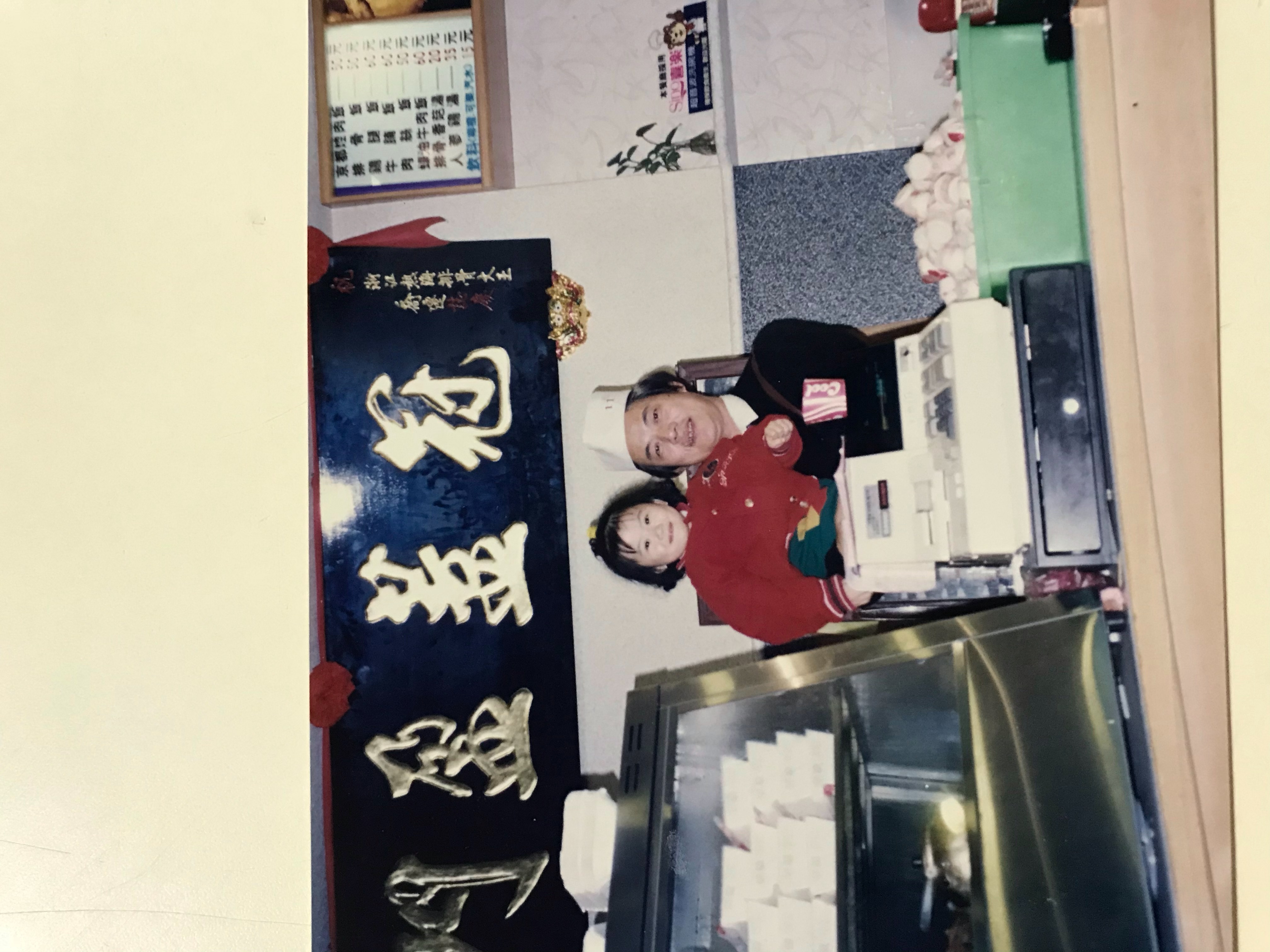 簡秋正43年前赴花蓮創業，生意穩定才把兒女接來團圓，圖為他抱著外孫女巡店。（簡鸝鴻提供）