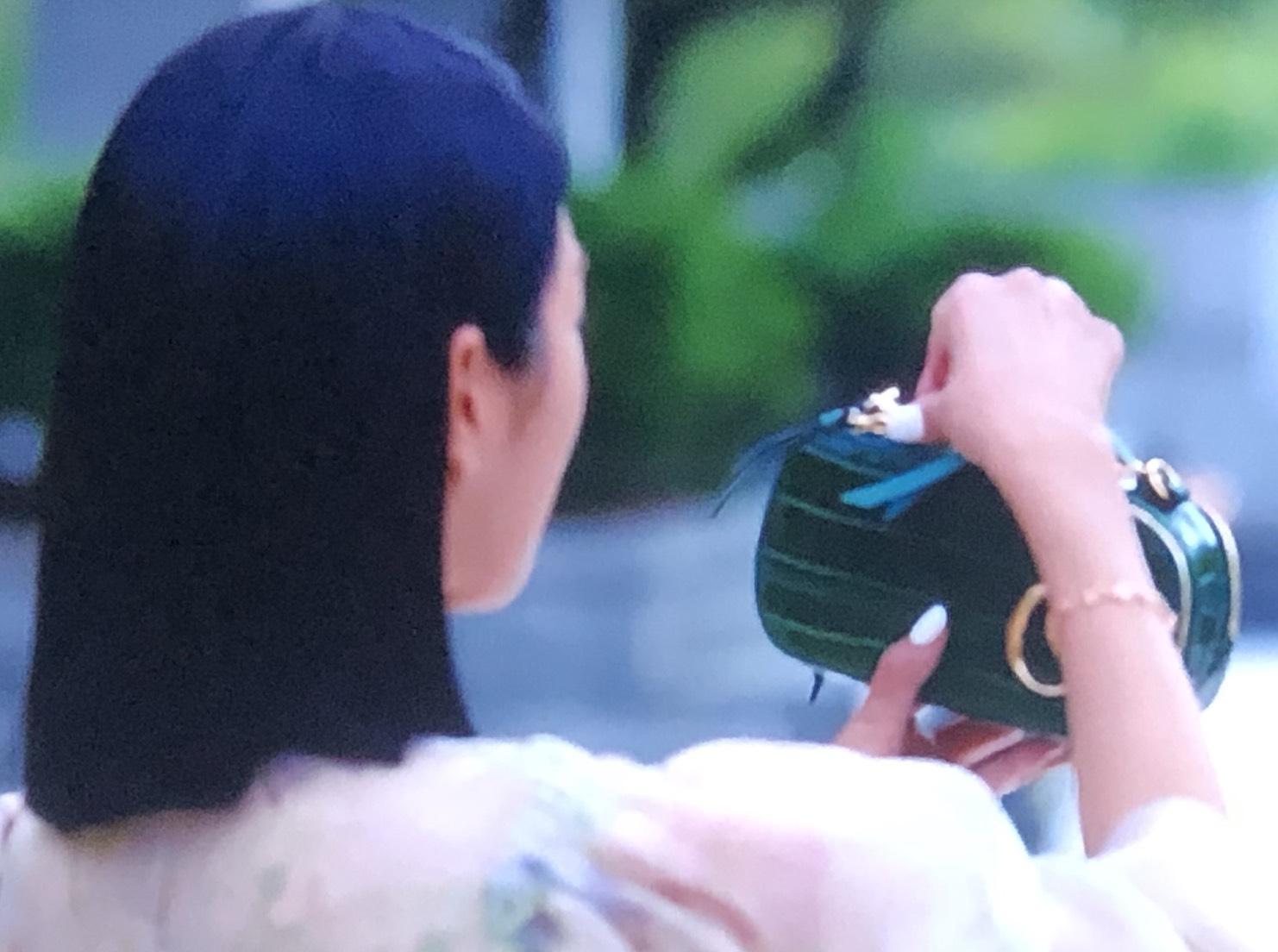 徐睿知在Chloé C綠色鱷魚皮壓紋相機包中,藏了她偷來的筆。(翻攝自NETFLIX)