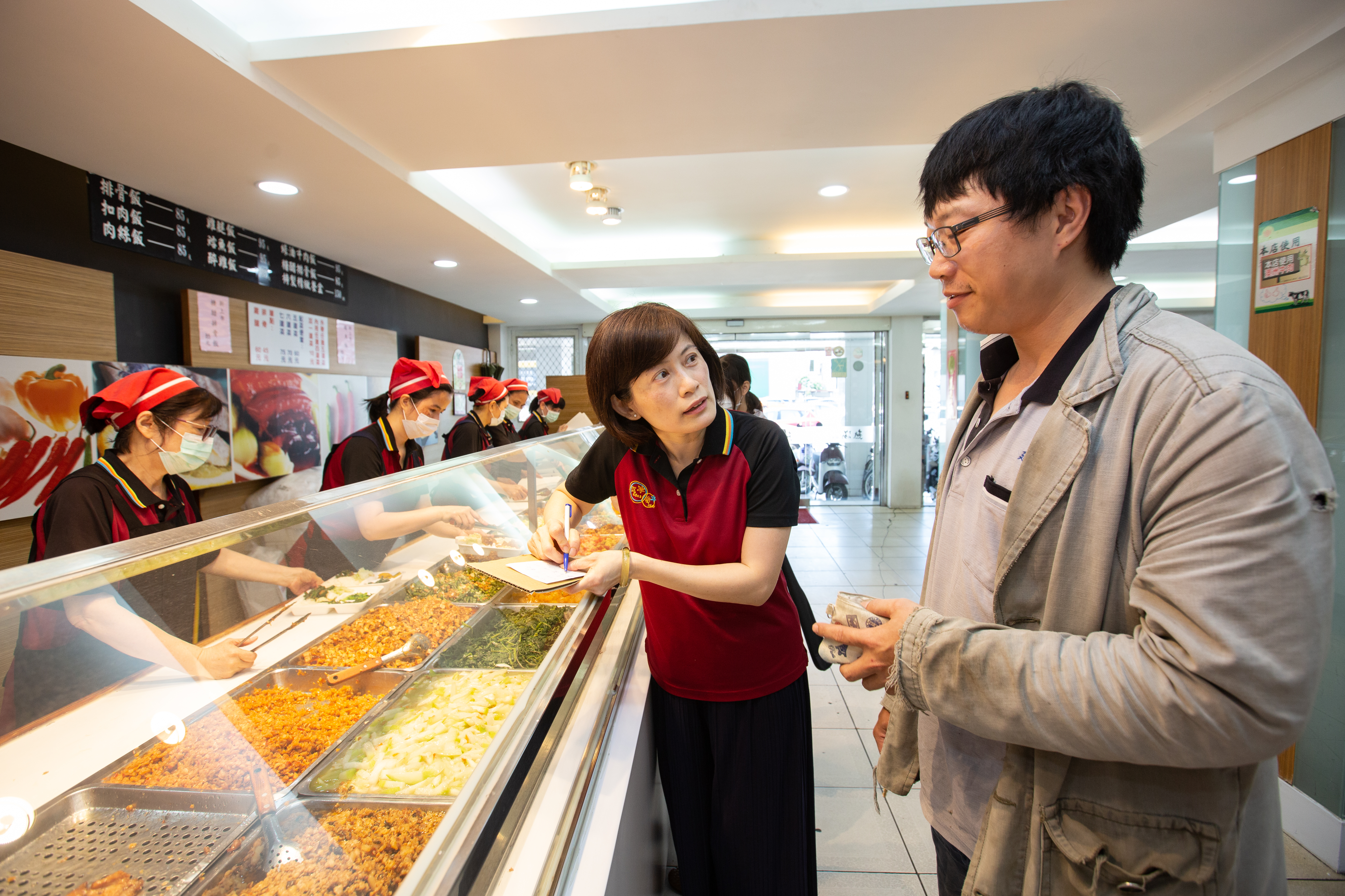 簡鸝鴻(右2)會仔細記下常客訂便當的菜單,避免連續2天配菜重複,也會貼心視訂購人需求調整配菜。