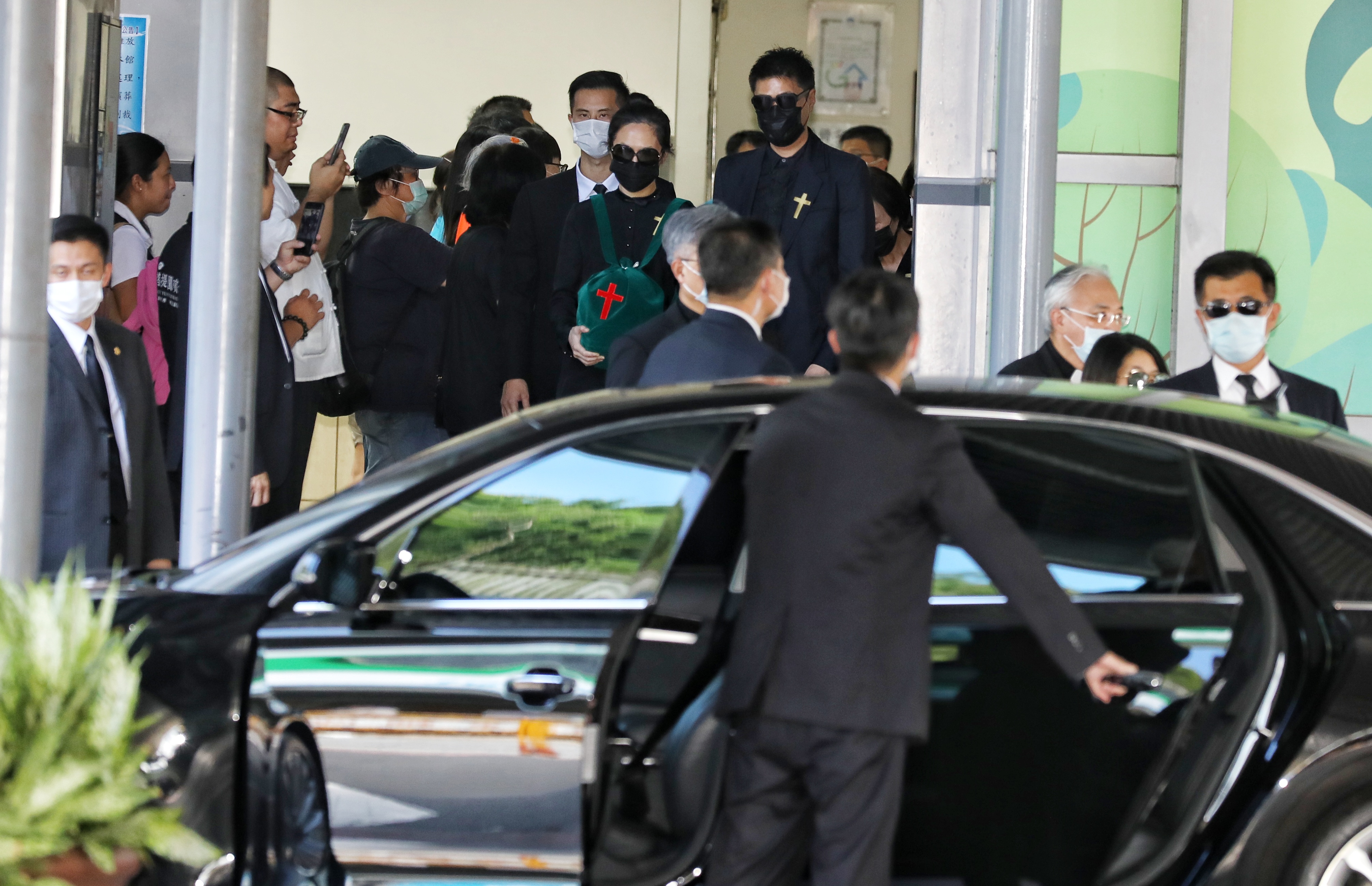 李登輝孫女李坤儀抱著李的骨灰步出火化場。