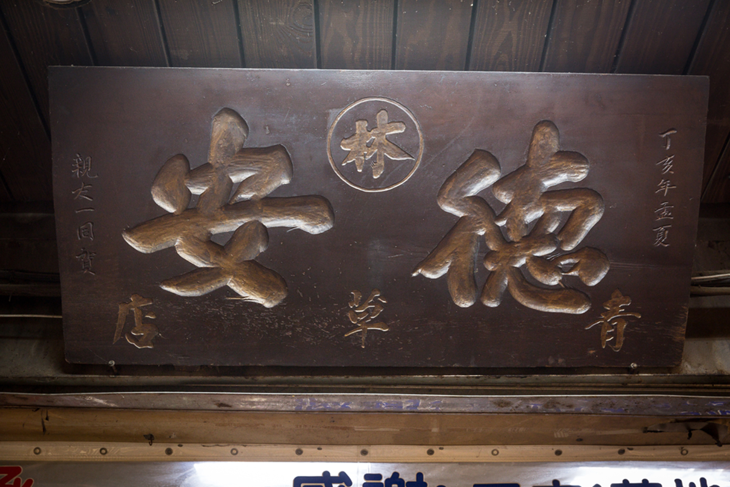 德安青草店本店掛著一方匾額，落款「丁亥年」（1947年），已有73年歷史。